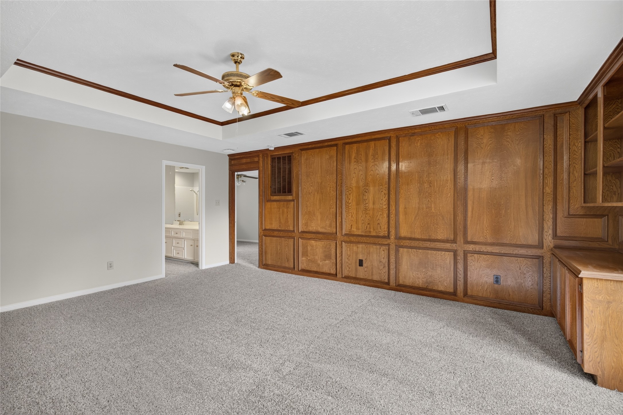 Built-in shelving, wood paneling, and a tray ceiling add character and functionality, creating a flexible space that can evolve with the way you live.