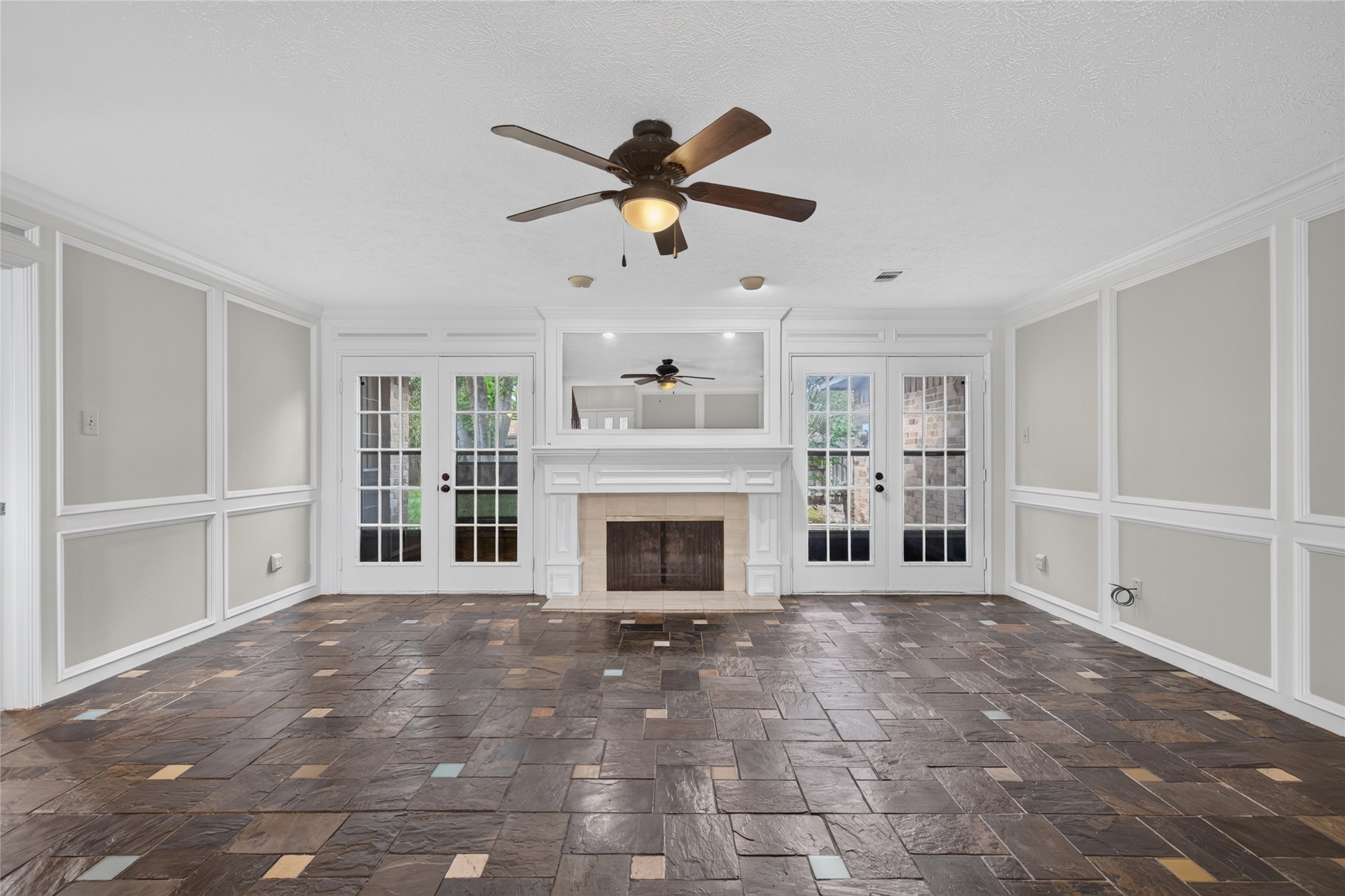 Double French doors flank the fireplace and bring the outdoors into view, while the open floor area provides plenty of flexibility for creating your ideal living arrangement.