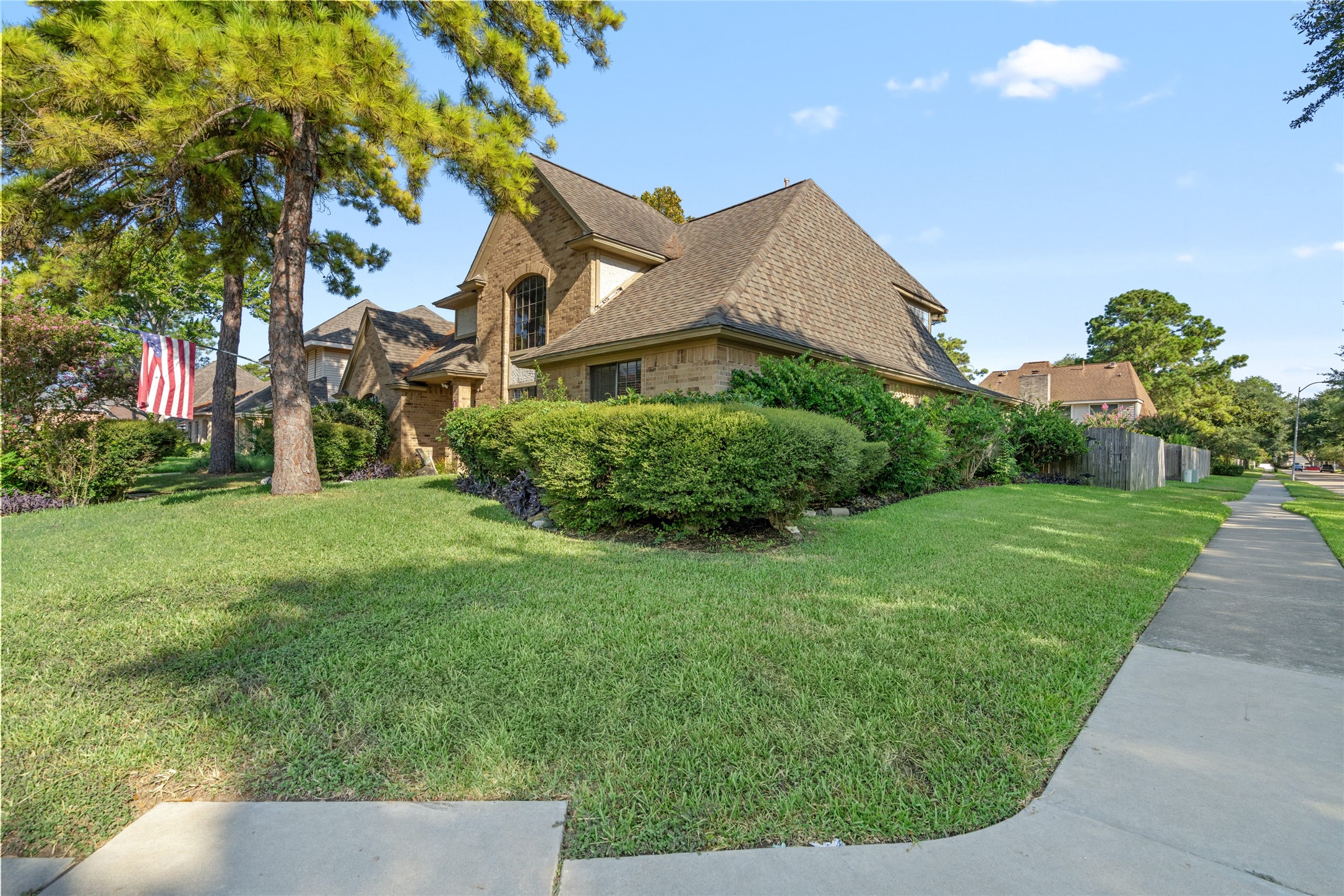 Positioned on a corner lot with a manicured lawn and mature trees, the home enjoys an open, welcoming presence with plenty of surrounding greenery.