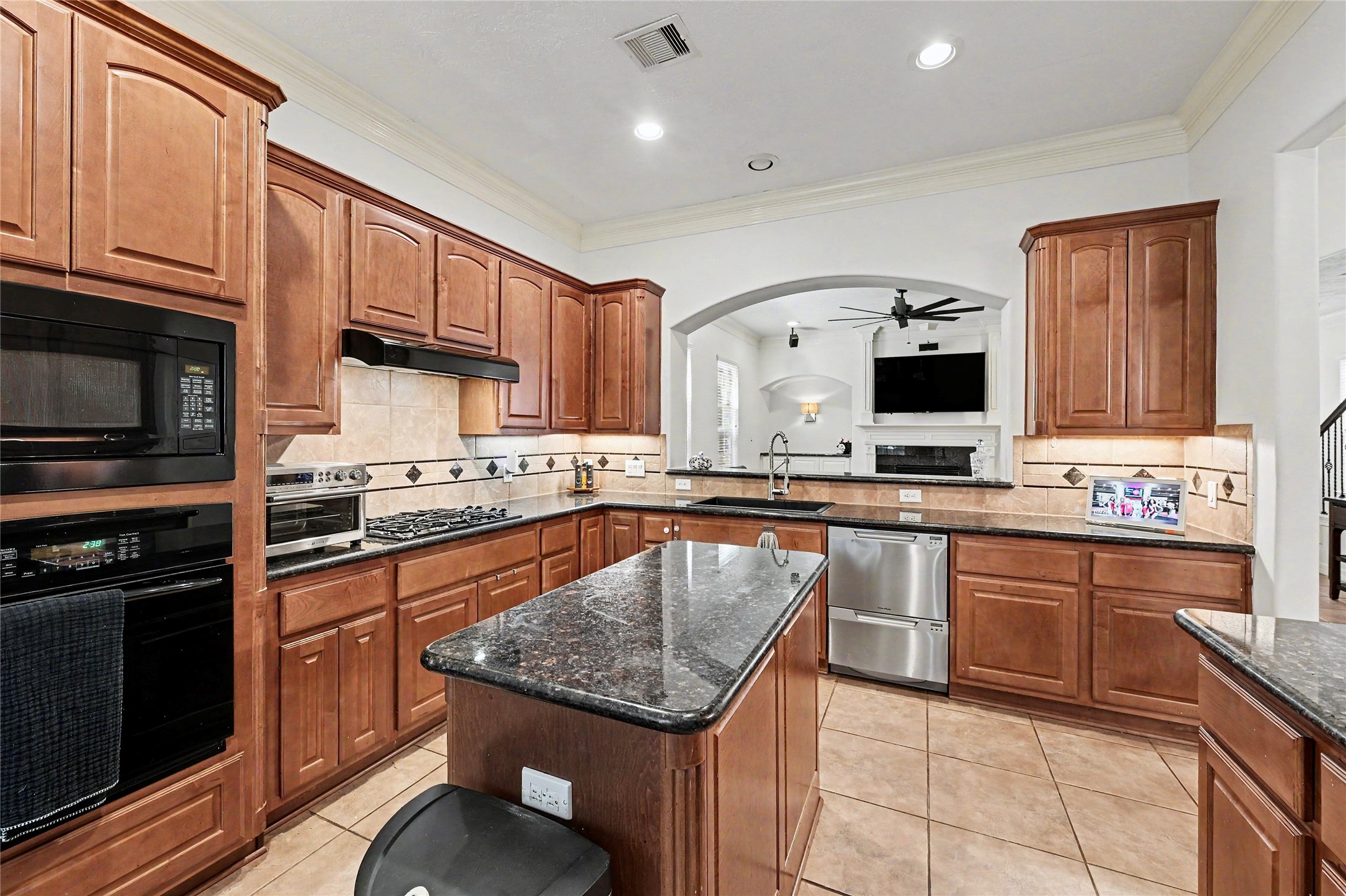 Additional kitchen view highlighting the center island, gas cooktop, and ample prep and storage space.