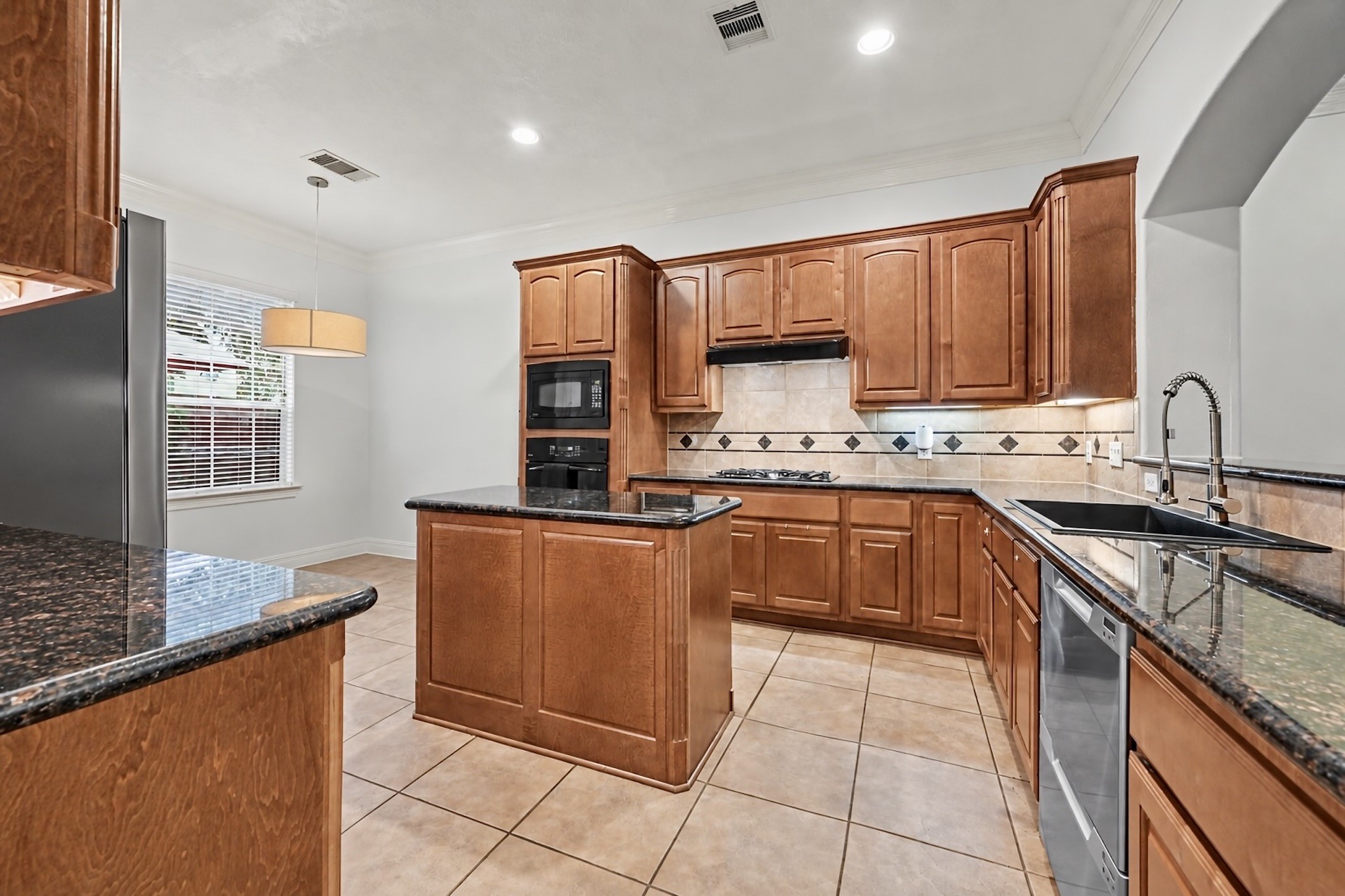 Stylish kitchen with granite countertops, stainless steel appliances, generous cabinetry, and breakfast bar. Virtually unstaged to highlight the rooms size and versatility