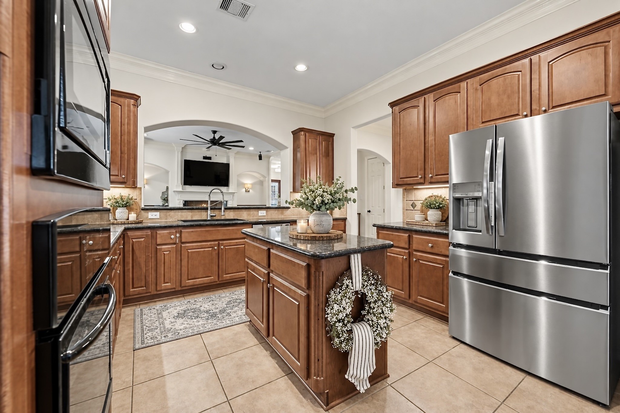 Stylish kitchen with granite countertops, stainless steel appliances, generous cabinetry, and breakfast bar. Virtually staged for inspiration.