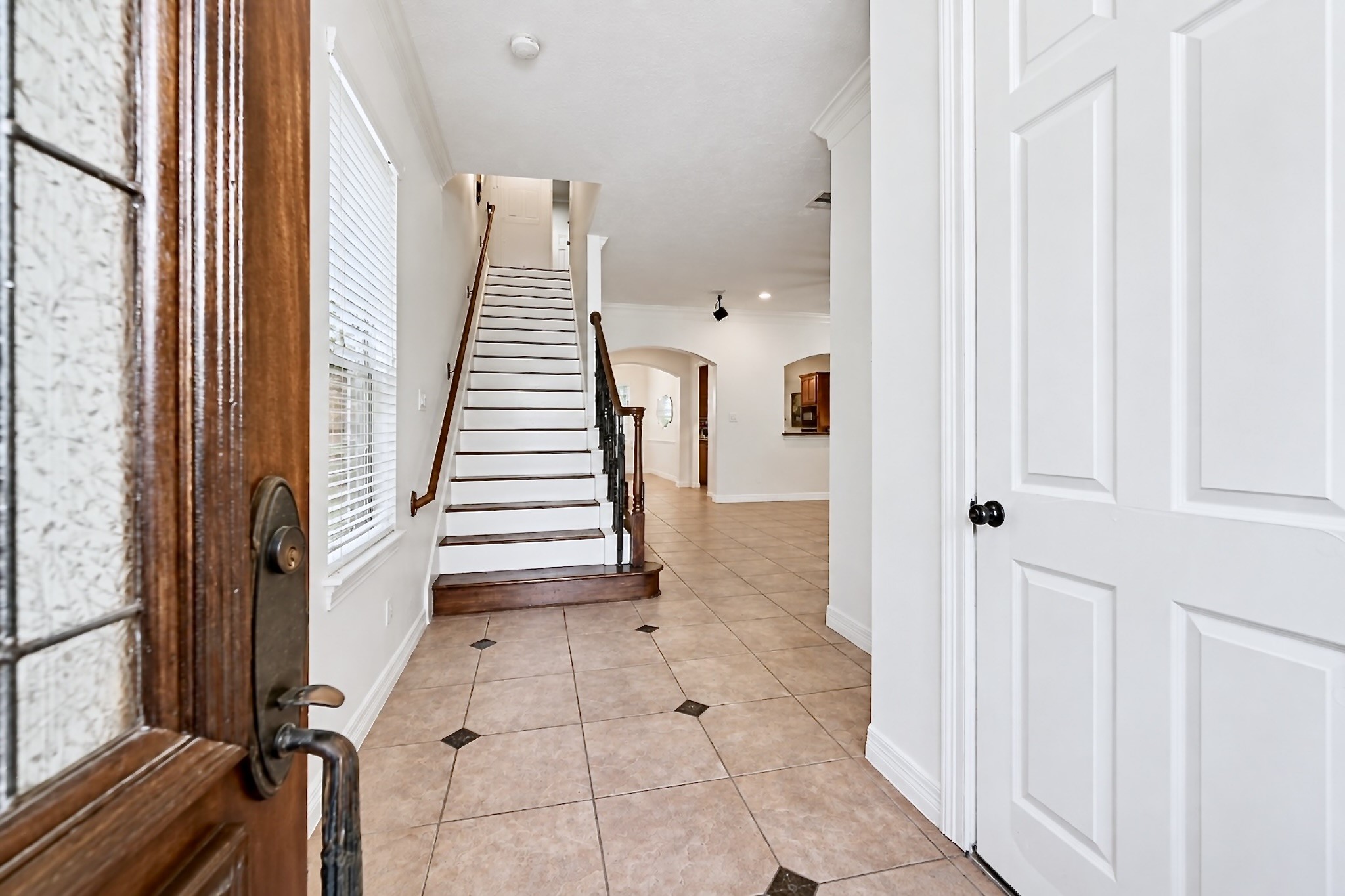 A gracious formal entry makes a striking first impression with its rich wood staircase.
