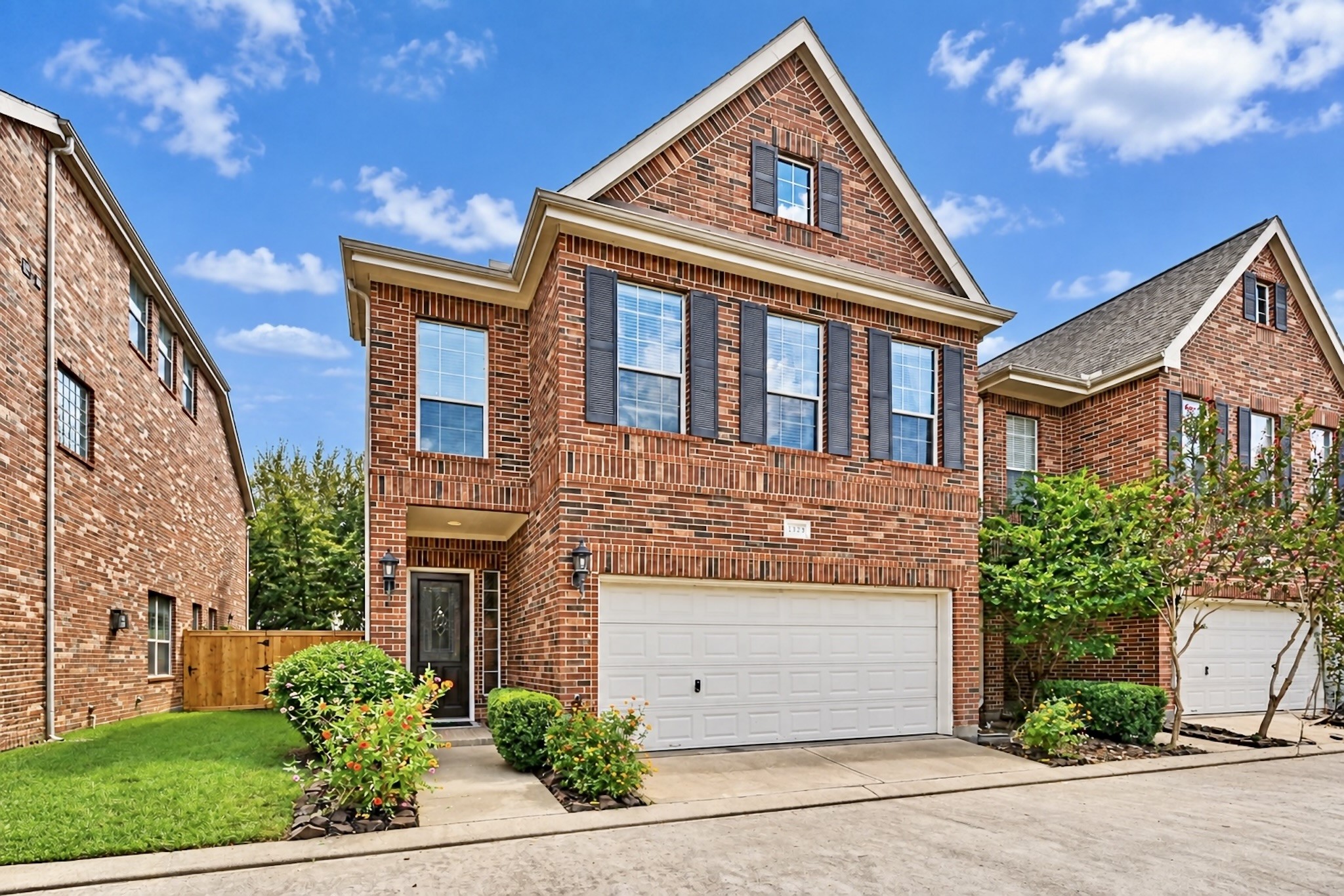 Elegant two-story brick residence with an attached two-car garage and welcoming front entry. Virtually enhanced photo.