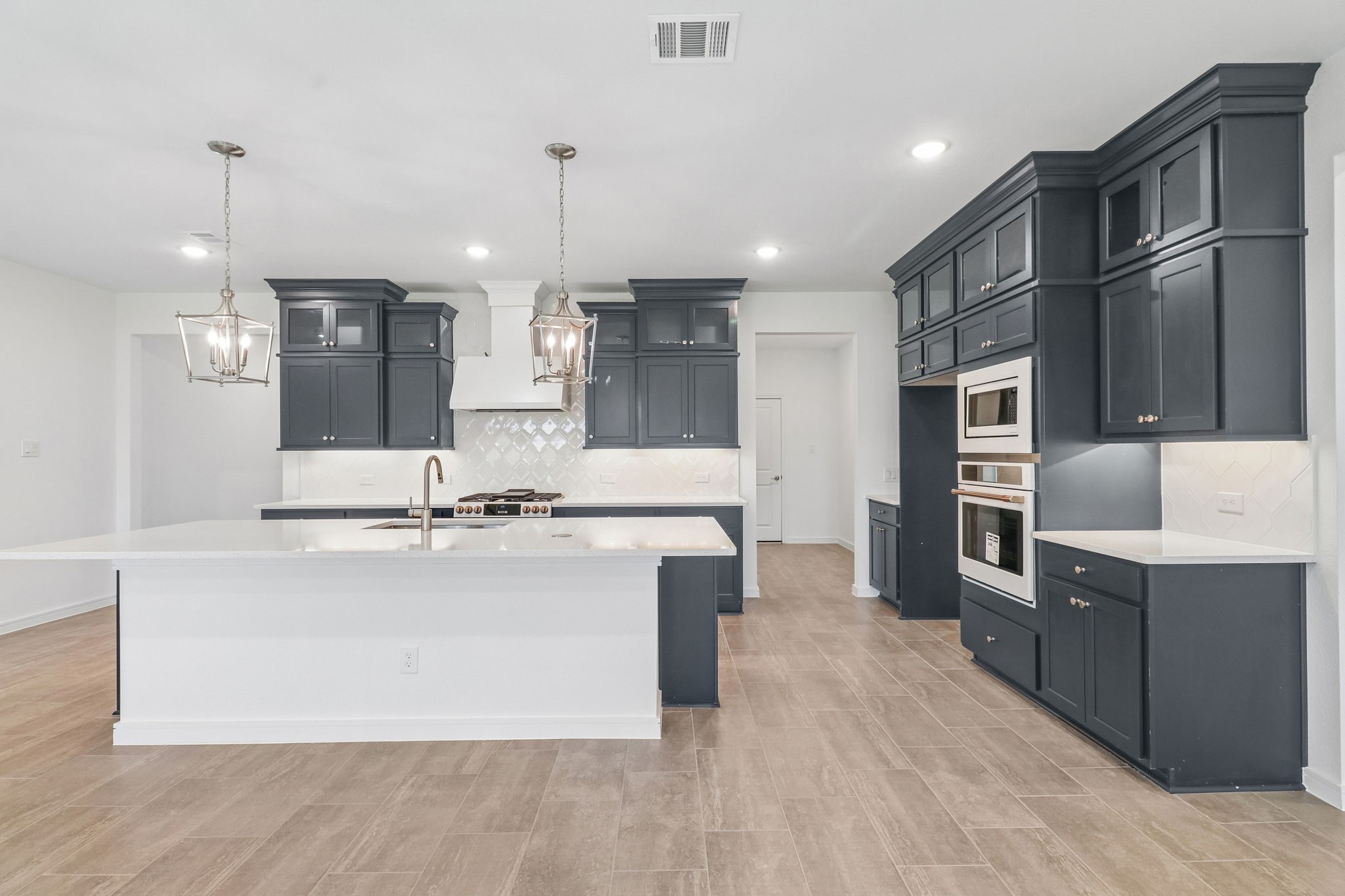 Upgraded kitchen with built in appliances, custom lighting, and intentional cabinetry.