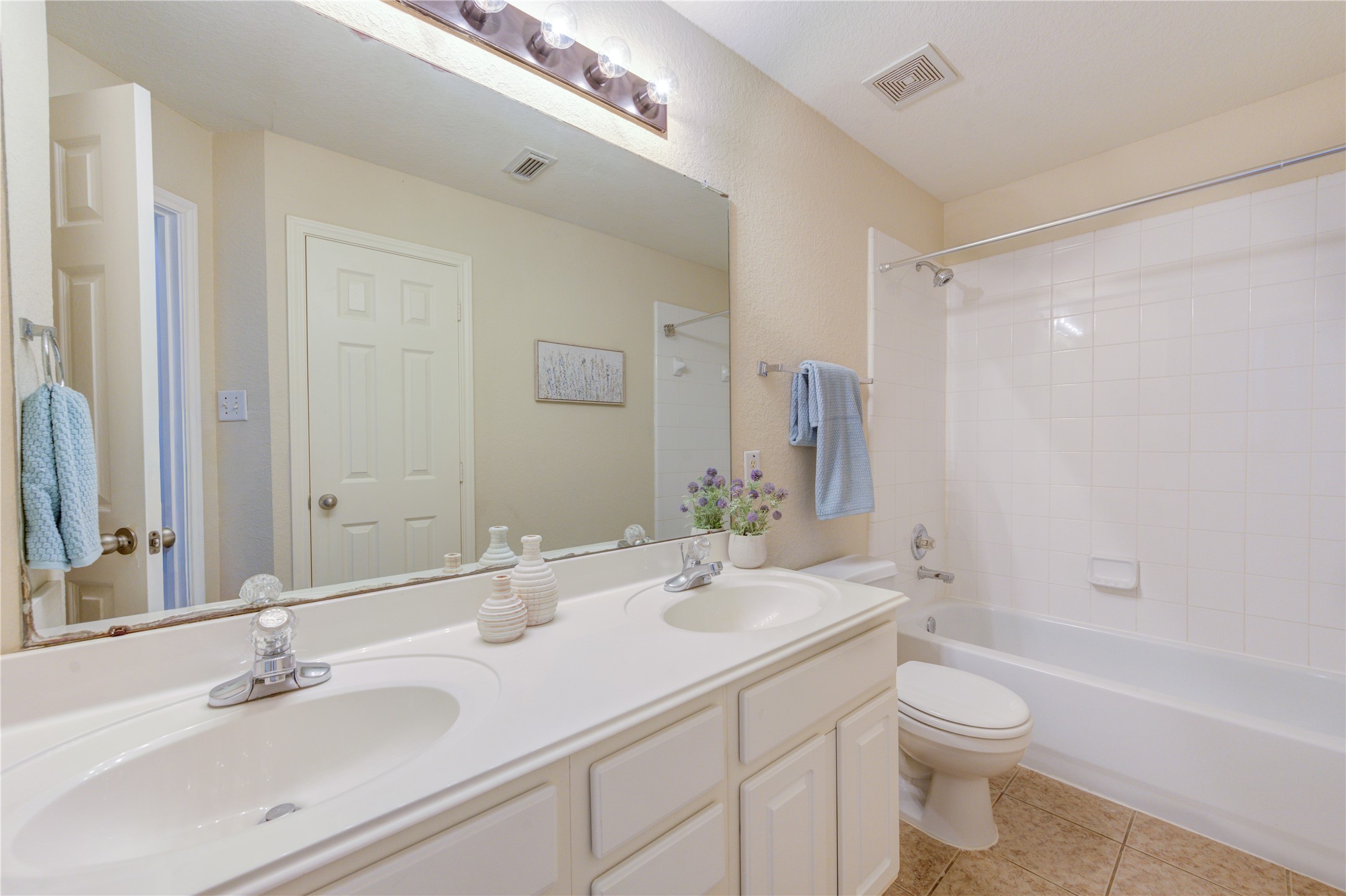 Spacious shared bath with dual sinks, abundant counter space, and a tub/shower combo perfect for busy mornings.