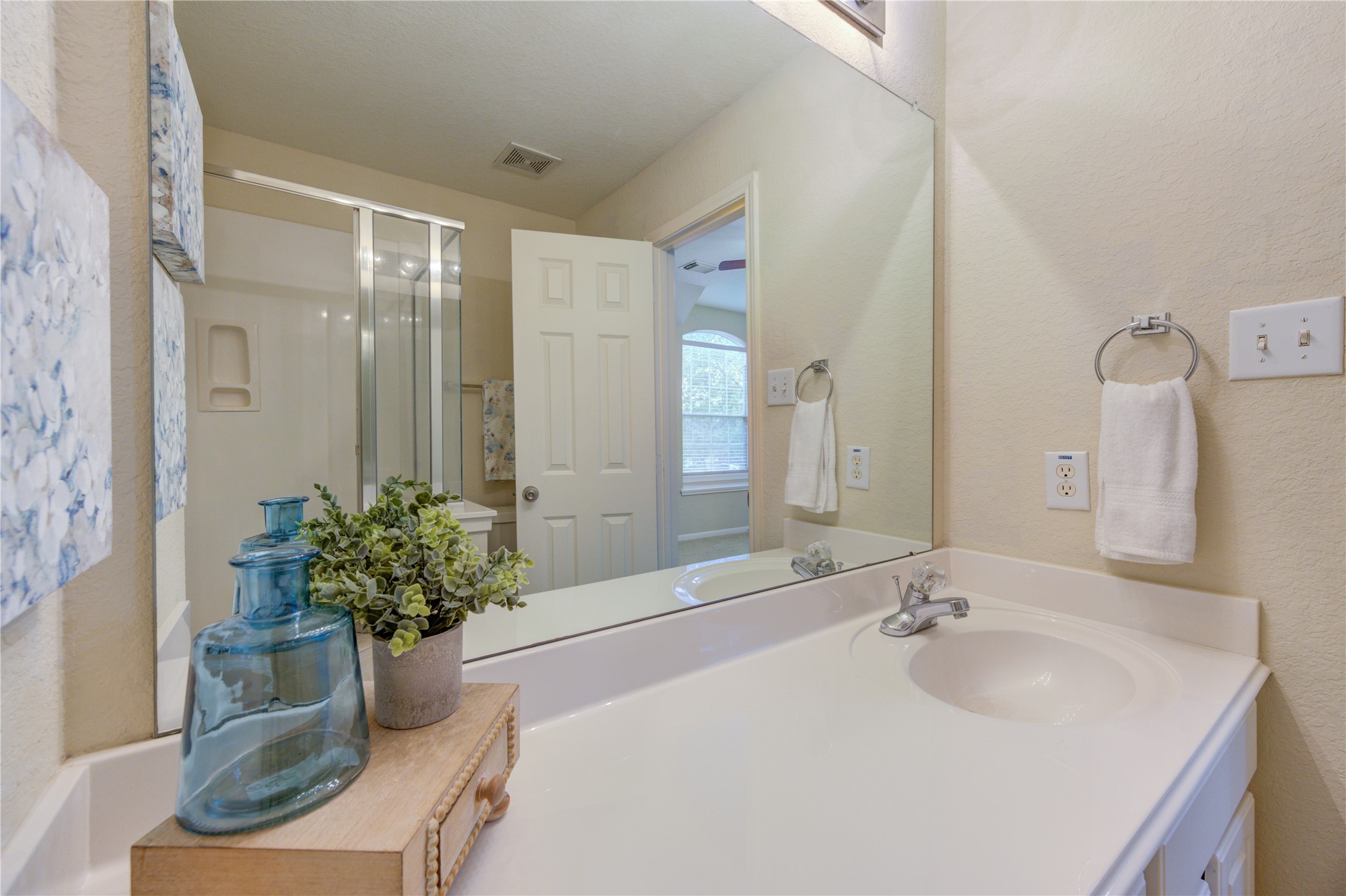 Private ensuite bath featuring a sleek vanity and walk-in shower for added comfort and convenience.
