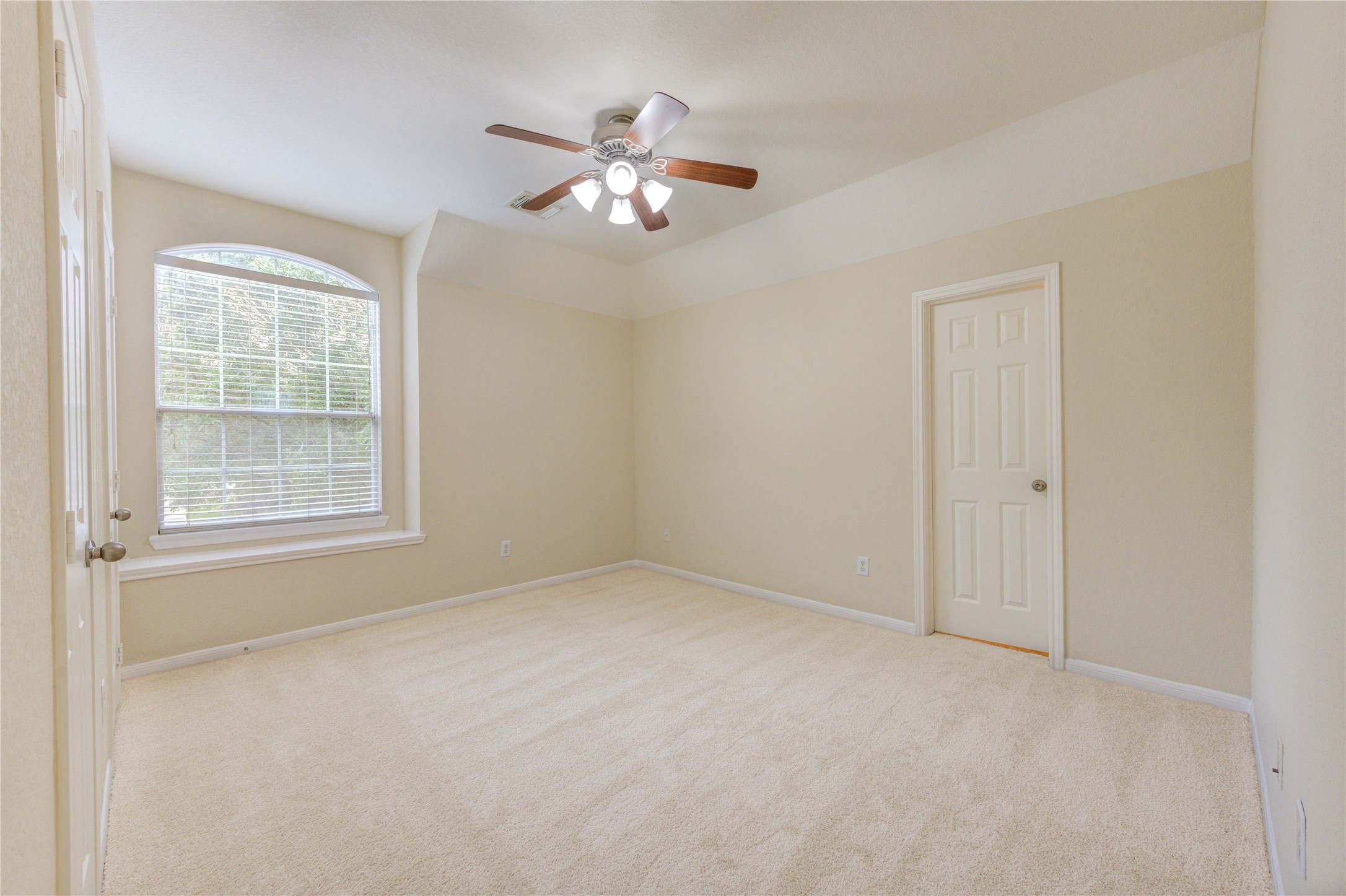 Comfortable guest suite bedroom with plush carpeting, soft natural light, and generous closet space.