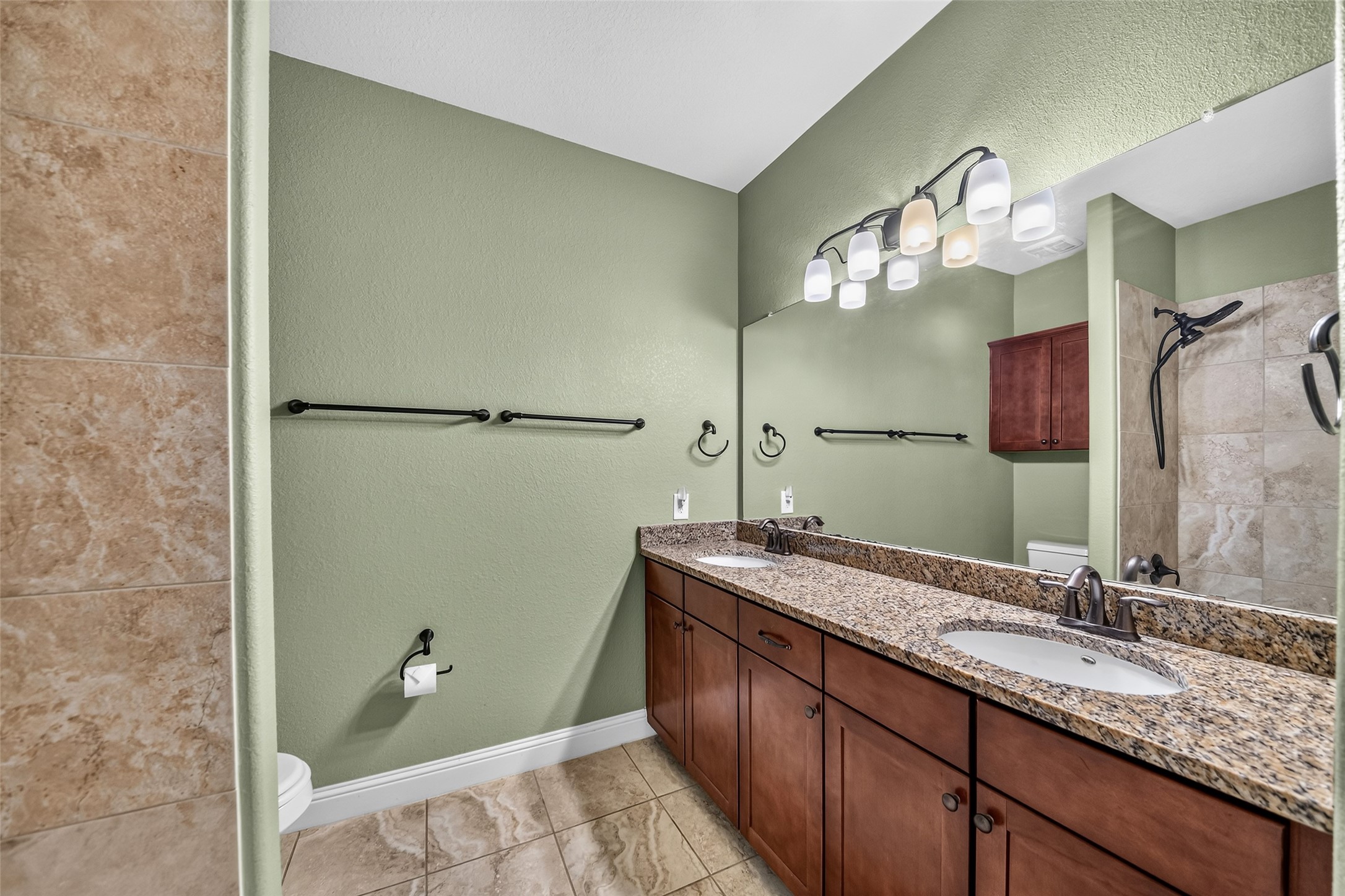 Elegant second full bathroom featuring a double sinks with granite countertops.