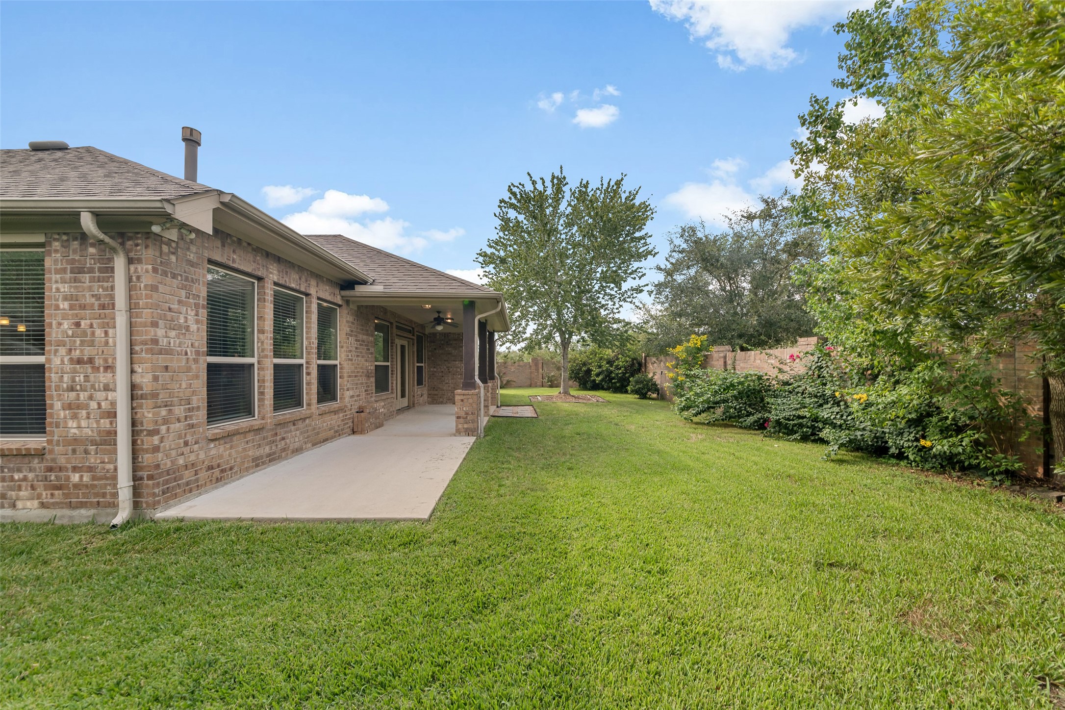 Lush lawn with mature trees providing shade and privacy.