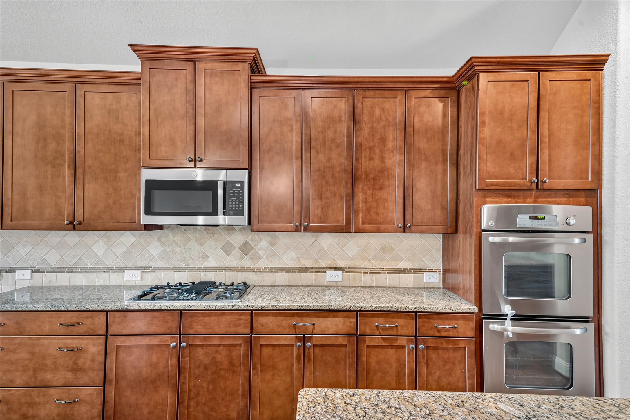 Stainless steel appliances and ample storage, including a built-in microwave and a double oven for your cooking convenience.