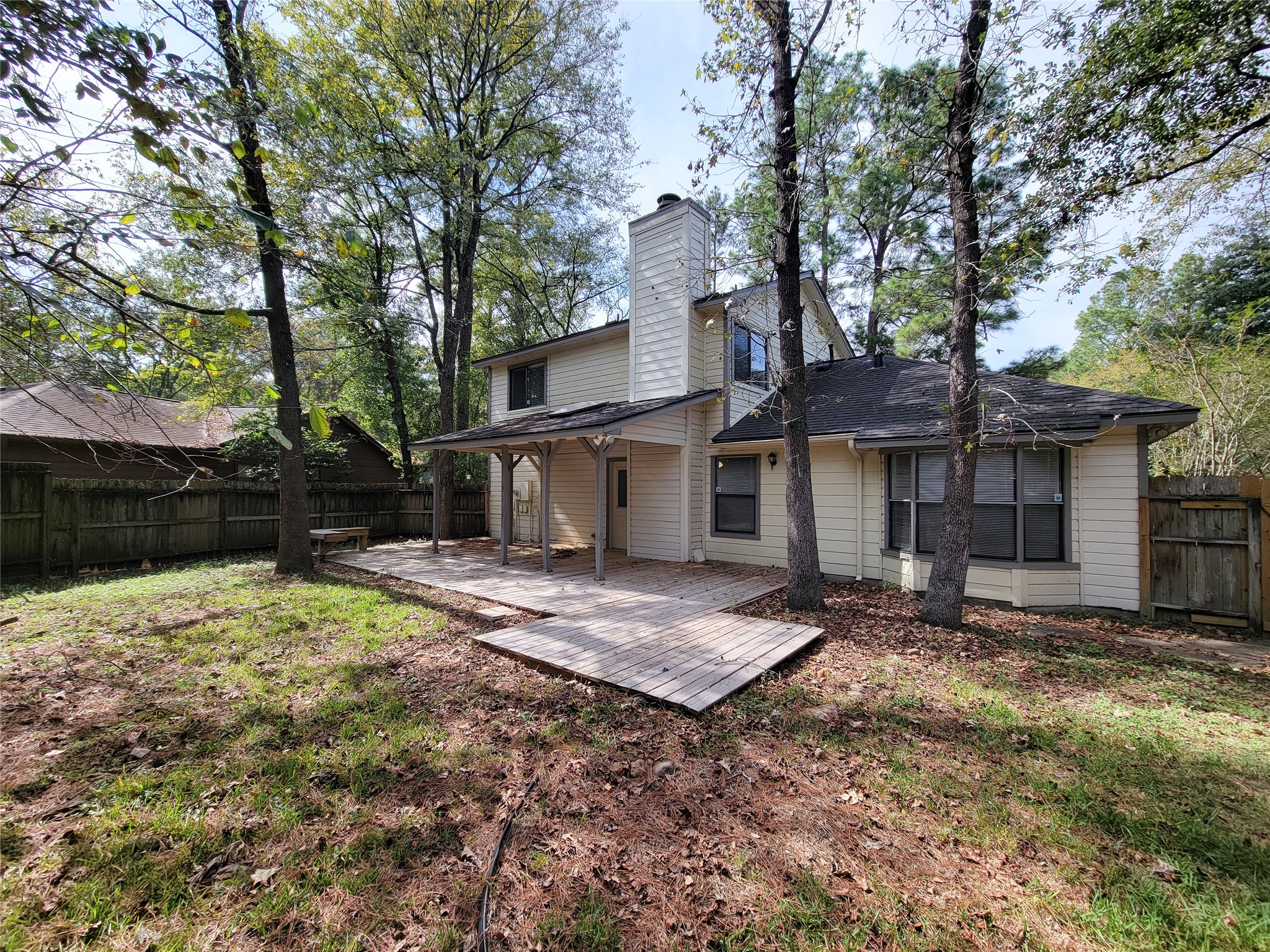Charming two-story home with a spacious backyard featuring a wooden deck, surrounded by mature trees for a serene outdoor retreat. Charming two-story home with a spacious backyard featuring a wooden deck, surrounded by mature trees for a serene outdoor retreat.
