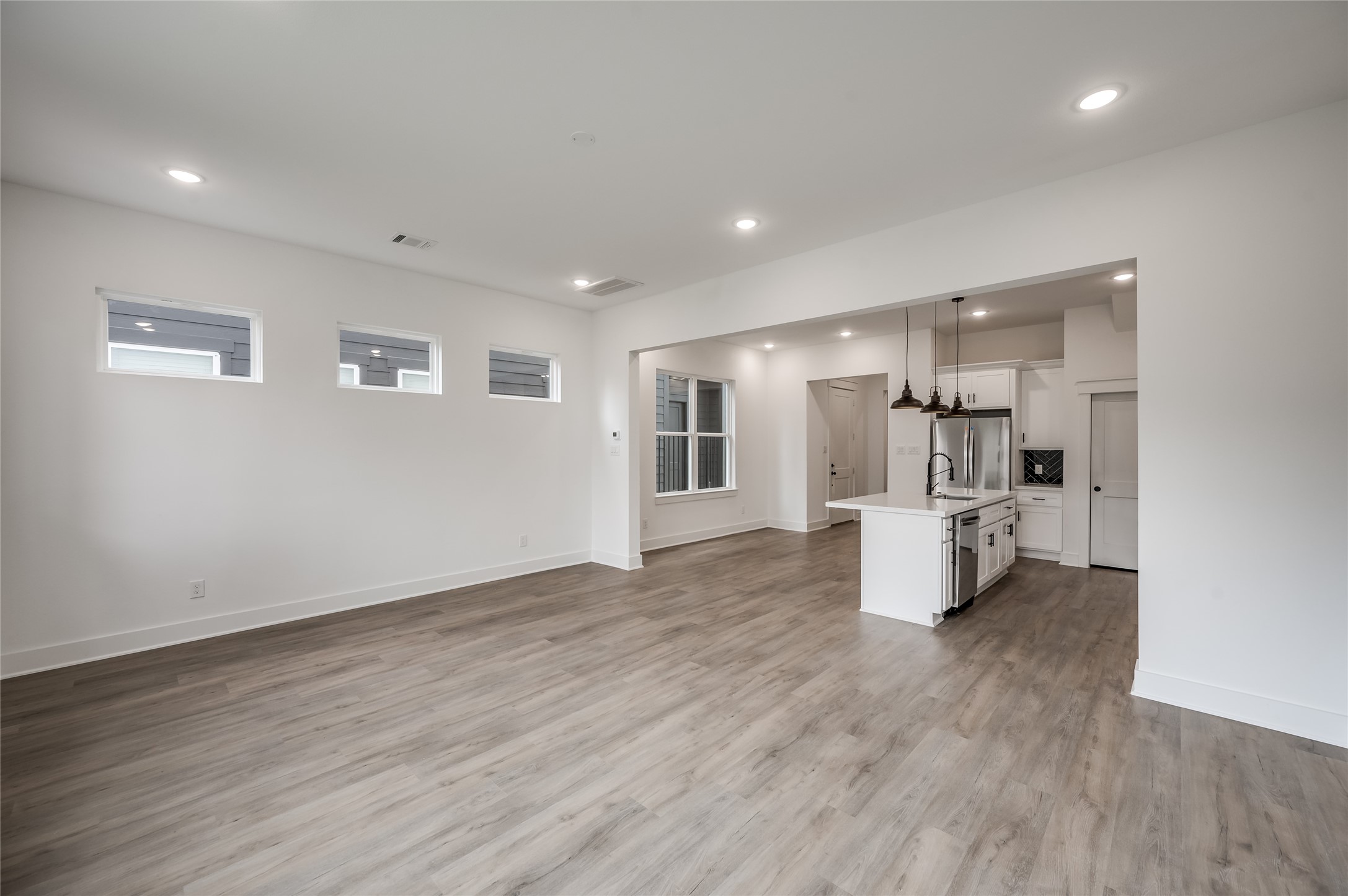 A wide angle view captures just how open the living room and kitchen feel together, made for gathering