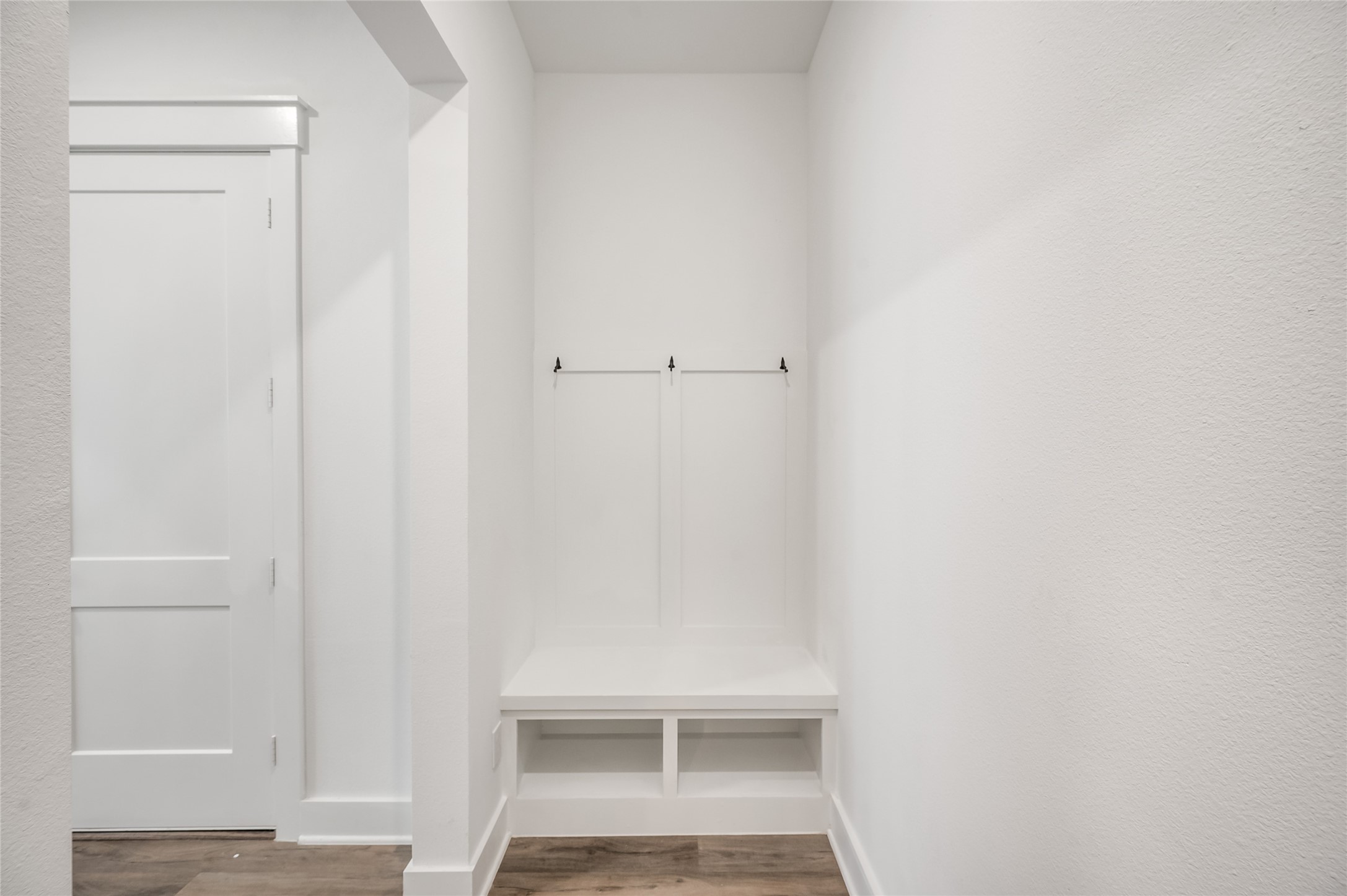 A charming built in bench with hooks by the garage entry makes for the perfect everyday drop zone