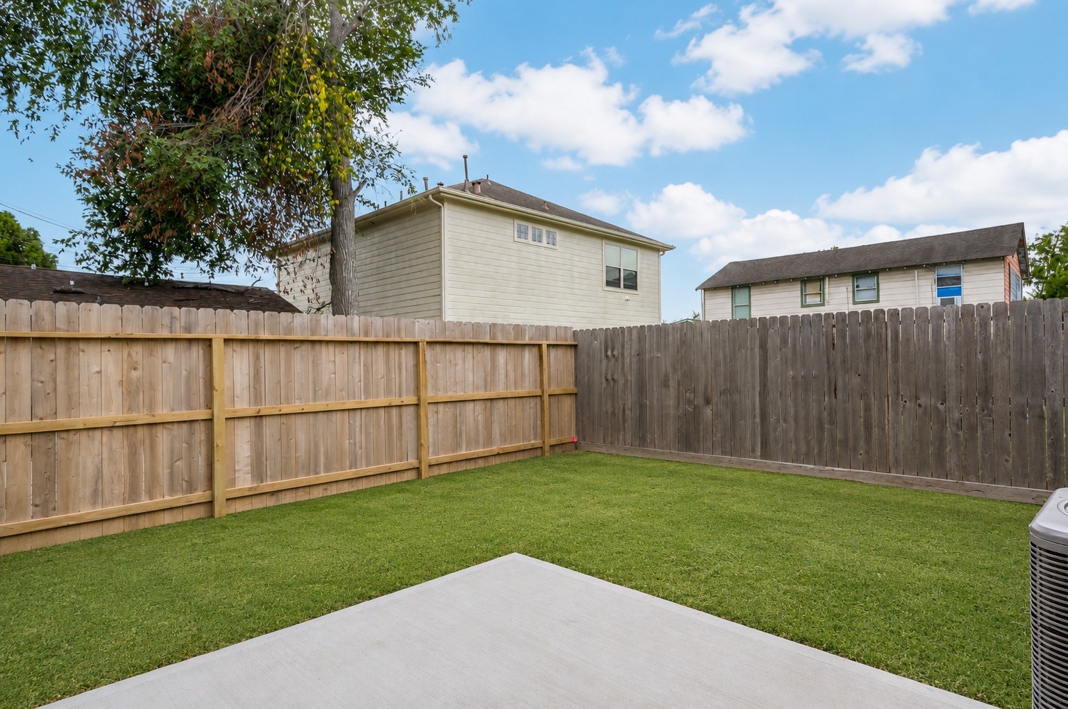 The fenced backyard offers a private patch of green, ready for pets, play, or relaxing evenings outside