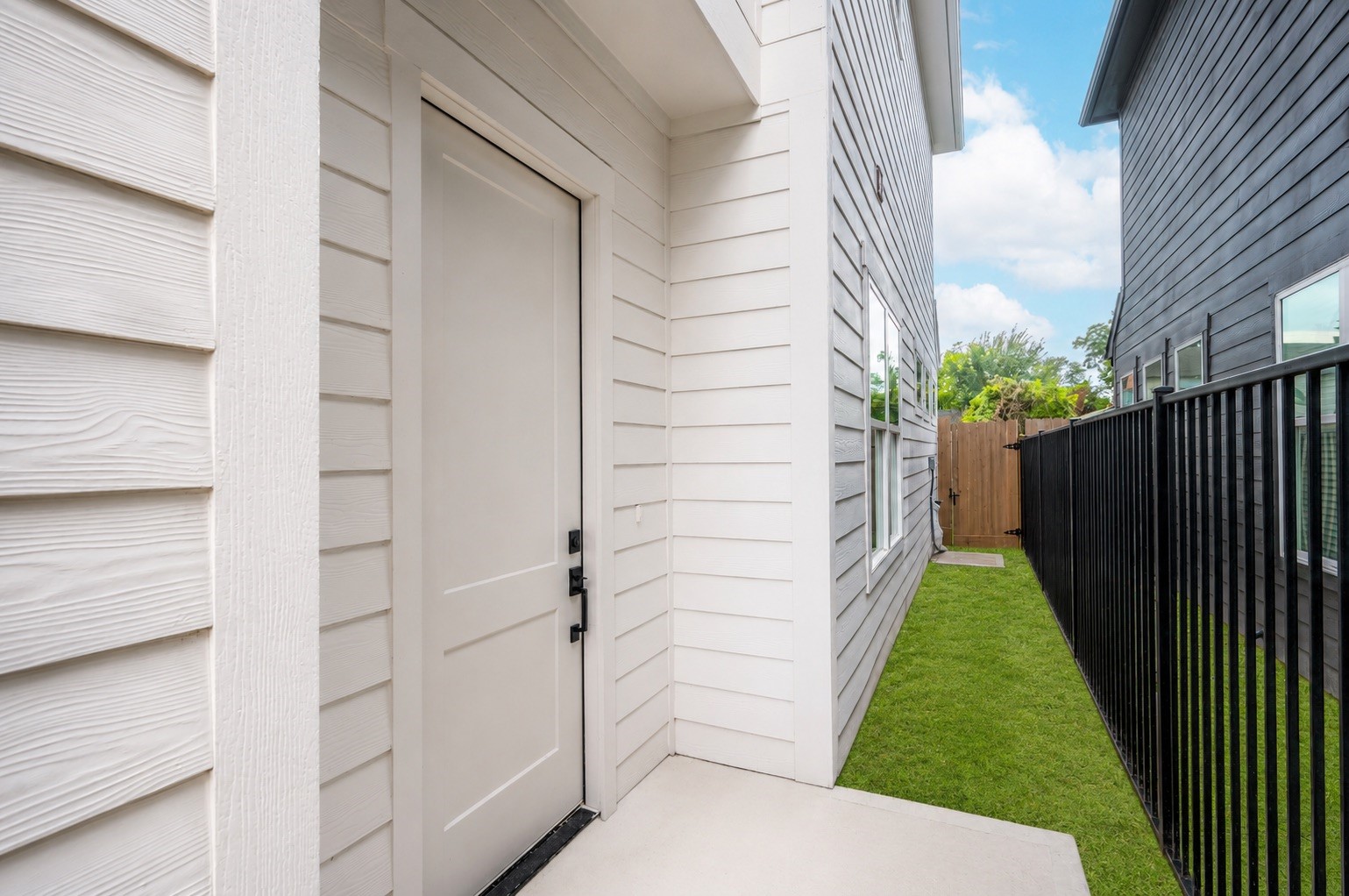 A tidy walkway leads you to the front door, framed by a fresh fence line that hints at the privacy waiting out back