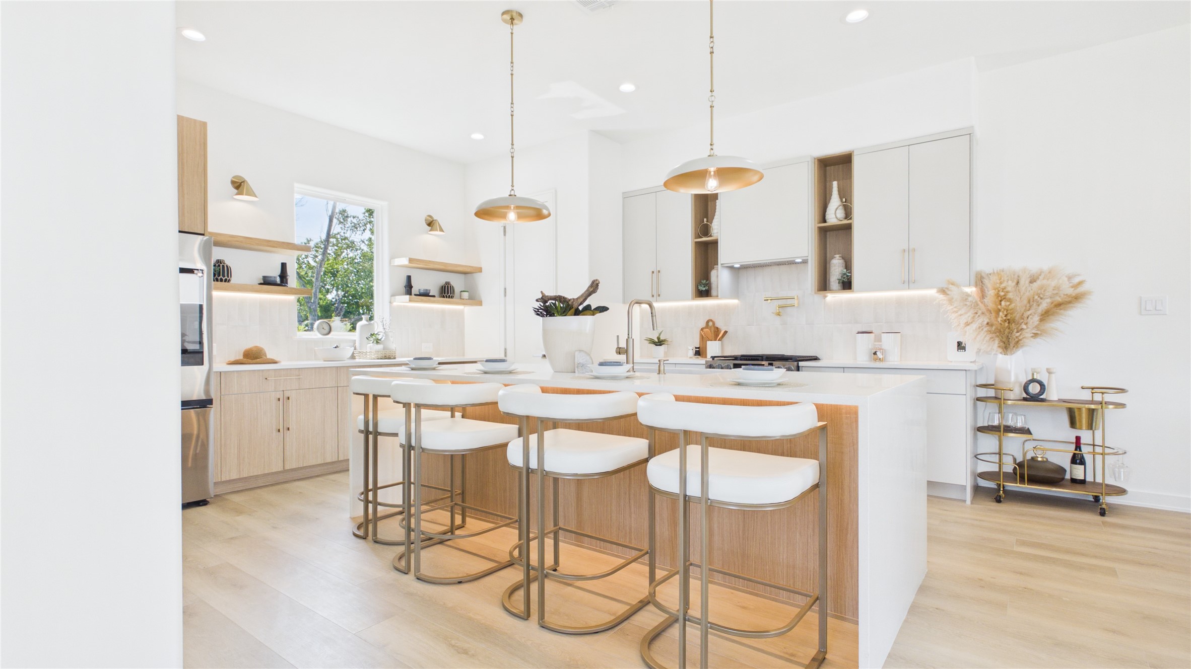 Modern kitchen featuring a spacious island with elegant bar seating, under island lighting, sleek cabinetry, and stylish pendant lighting, perfect for entertaining.