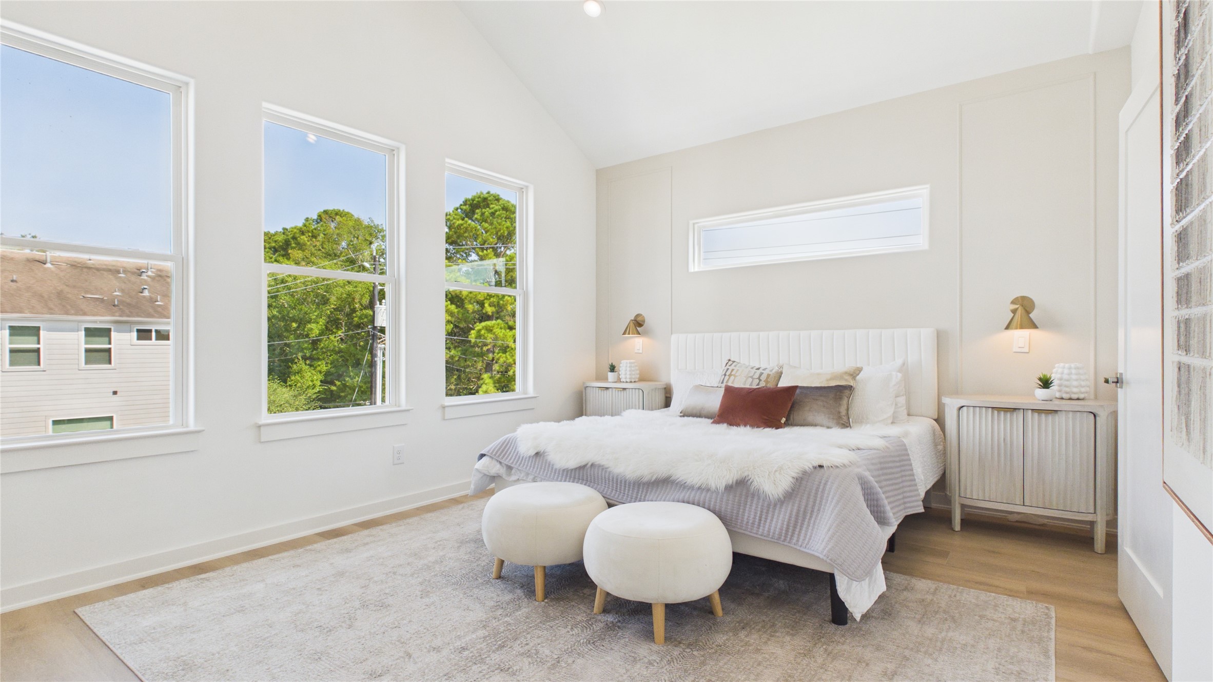 Primary bedroom featuring cathedral ceilings and complemented by a soft, neutral palette.