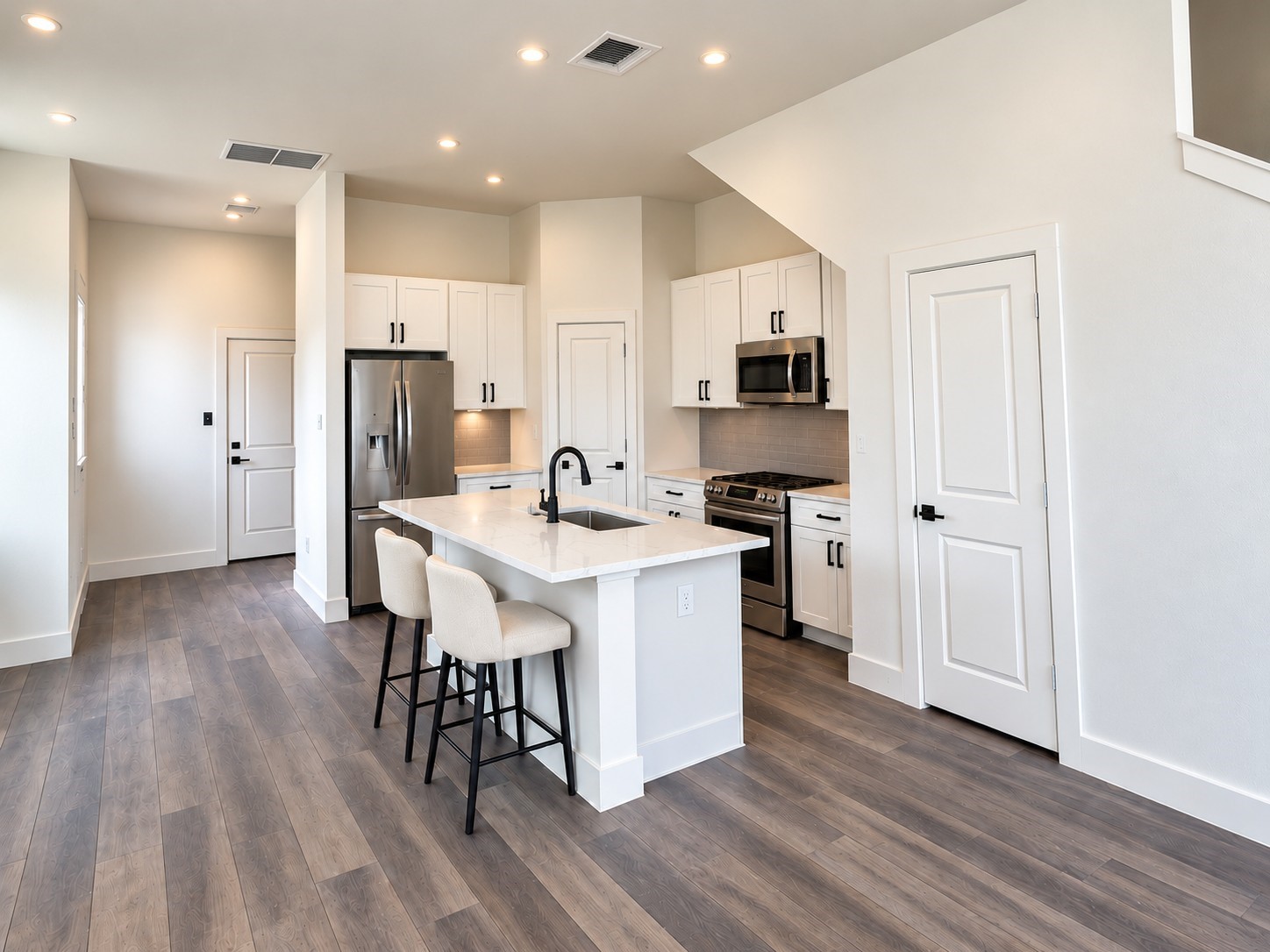 Step into this bright, modern kitchen showcasing a beautiful combination of style, comfort, and functionality. Crisp white shaker-style cabinets, elegant stone-look countertops, and a coordinating tile backsplash create a timeless aesthetic. Stainless steel appliances and matte black fixtures add contemporary sophistication. The spacious center island features an undermount sink and comfortable seating for casual meals or conversation. These photos have been virtually rendered for visual reference. Step into this bright, modern kitchen showcasing a beautiful combination of style, comfort, and functionality. Crisp white shaker-style cabinets, elegant stone-look countertops, and a coordinating tile backsplash create a timeless aesthetic. Stainless steel appliances and matte black fixtures add contemporary sophistication. The spacious center island features an undermount sink and comfortable seating for casual meals or conversation. These photos have been virtually rendered for visual reference.