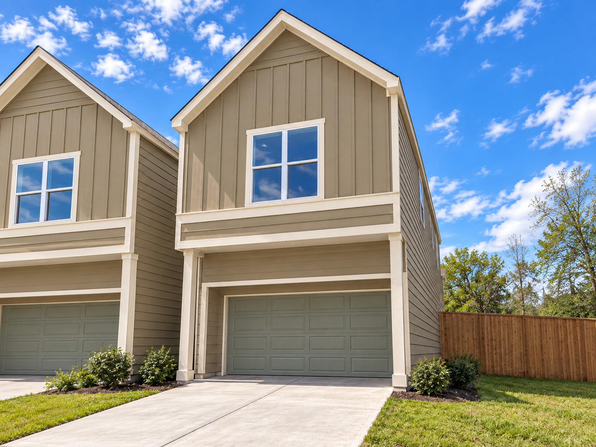 Enjoy the striking curb appeal of this contemporary two-story home, beautifully accented by neutral exterior siding, contrasting white trim, and classic gabled rooflines. The welcoming facade features a spacious attached garage and concrete driveway, offering practical parking and accessibility. Thoughtfully arranged shrubs, a neatly maintained lawn, and a wooden privacy fence complement the home's clean architectural design. These photos have been virtually rendered for visual reference.