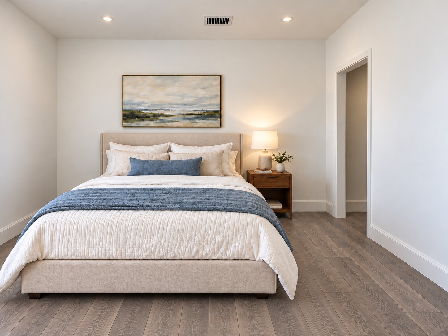 Step into this inviting bedroom featuring a soothing neutral color palette, beautiful wood-look flooring, and a bright, airy atmosphere. The spacious layout comfortably accommodates a large upholstered bed, complemented by elegant bedding, warm wood furnishings, and tasteful wall artwork. Recessed ceiling lighting provides a clean, modern finish, while crisp white walls create a timeless backdrop. These photos have been virtually rendered for visual reference. Step into this inviting bedroom featuring a soothing neutral color palette, beautiful wood-look flooring, and a bright, airy atmosphere. The spacious layout comfortably accommodates a large upholstered bed, complemented by elegant bedding, warm wood furnishings, and tasteful wall artwork. Recessed ceiling lighting provides a clean, modern finish, while crisp white walls create a timeless backdrop. These photos have been virtually rendered for visual reference.