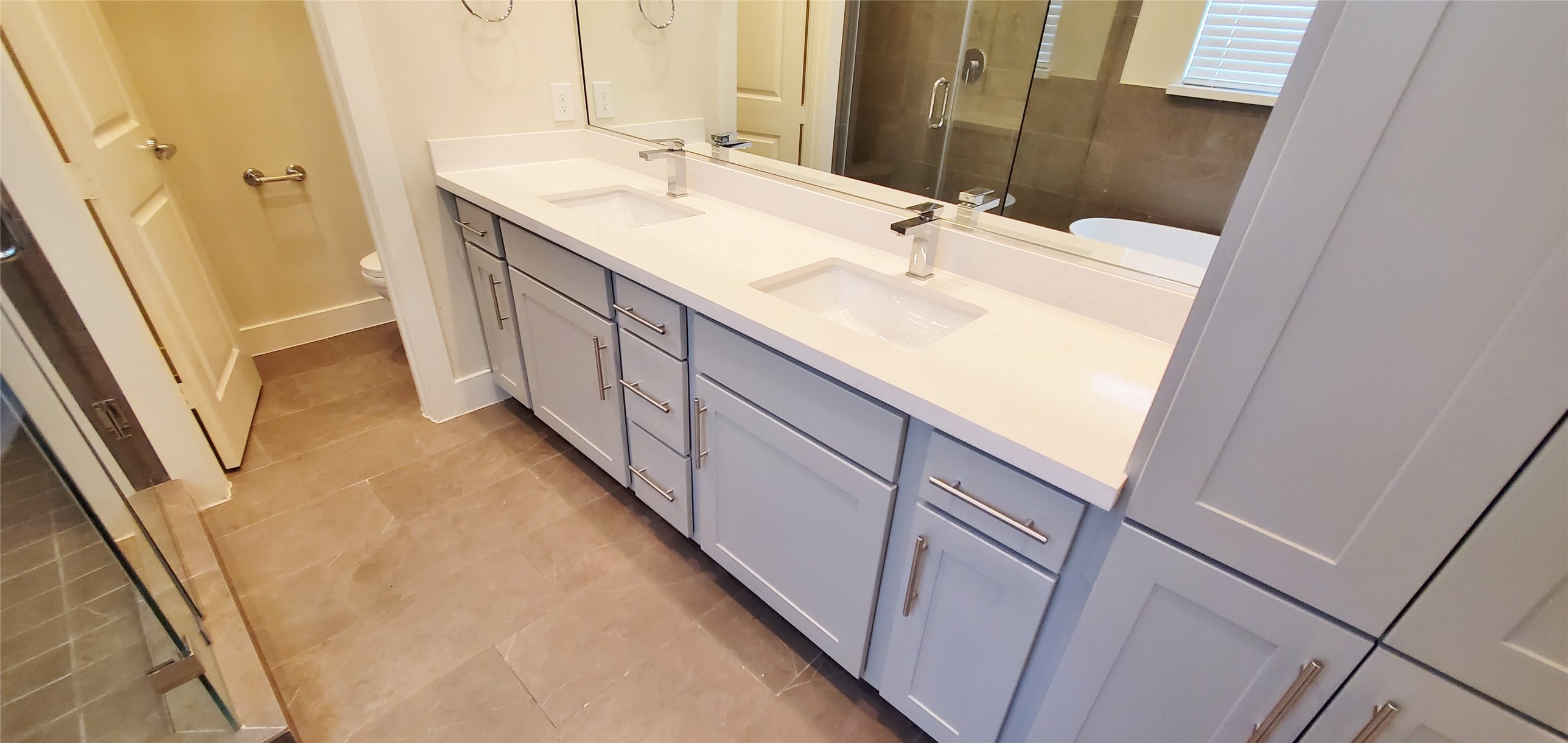 Primary bathroom with two sinks and ample storage