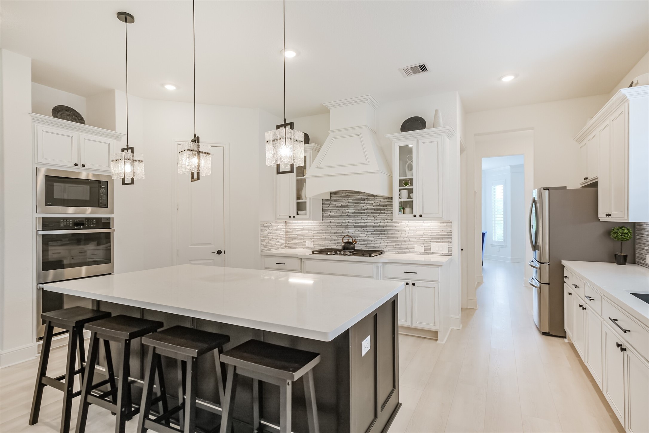 Thoughtfully designed gourmet kitchen featuring custom Benedettini cabinetry and elevated storage solutions throughout. Custom soft-glide drawers include peg organization, a built-in silverware organizer, and a dedicated coffee mug drawer, while under-cabinet lighting throughout adds warmth and highlights the exceptional craftsmanship. A sleek built-in microwave integrates seamlessly into the cabinetry, creating a sophisticated kitchen where luxury and functionality meet.