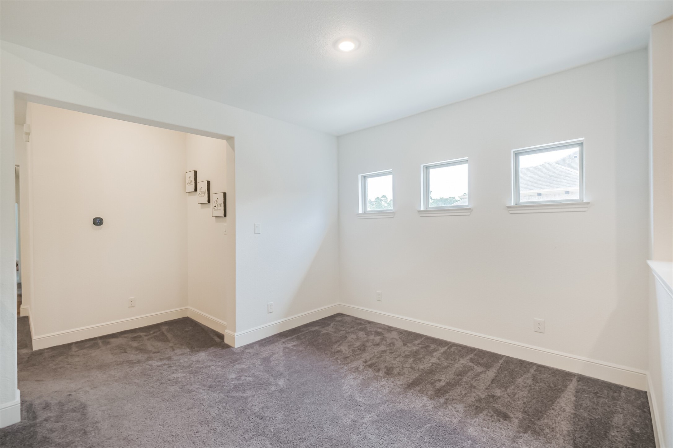 Charming bonus space filled with natural light from three windows and finished with plush carpeting. A recessed wall niche provides the perfect opportunity to showcase artwork, dcor, or a custom design feature, adding character and versatility to the space.