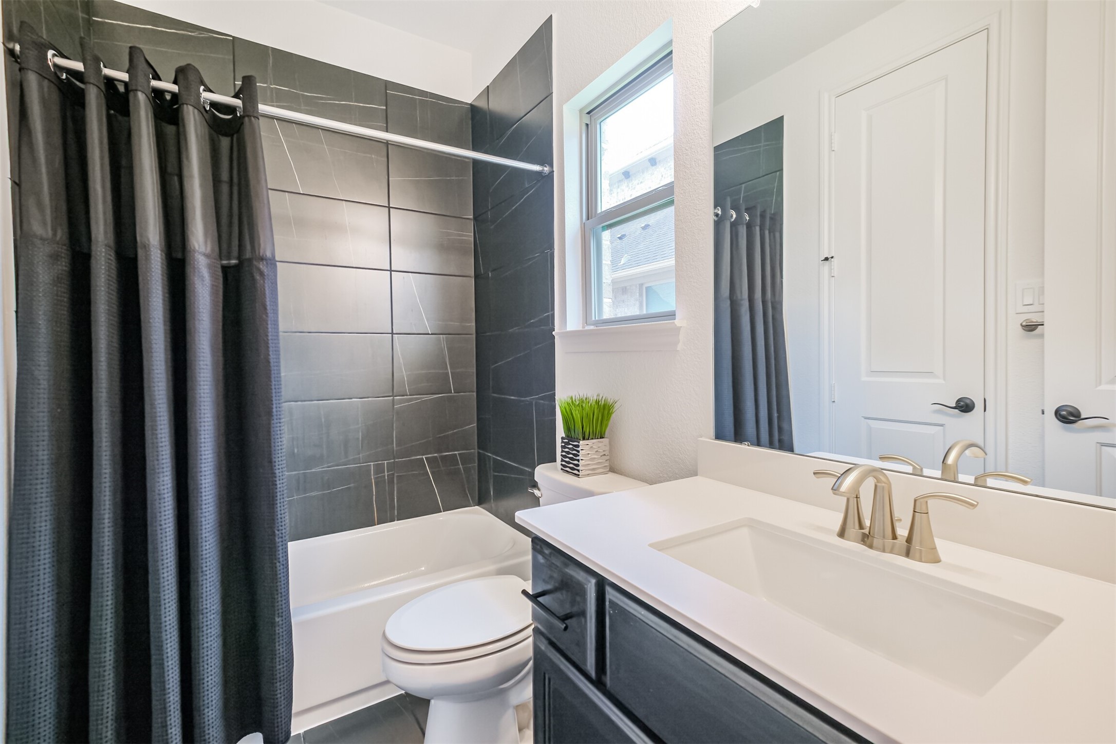 Private downstairs guest suite/third bedroom is complete with its own beautifully appointed en-suite bathroom, featuring a sleek tiled tub and shower combinationoffering guests comfort, convenience, and exceptional privacy.
