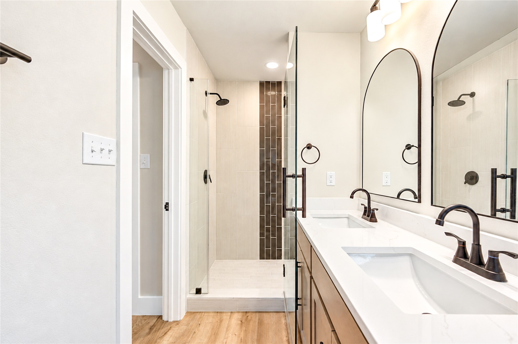 Stunning new primary shower showcases vertically installed 12x24 tile, decorative glass mosaic accents, and a sleek new frameless glass shower door. Home features all-new PEX plumbing throughout!
