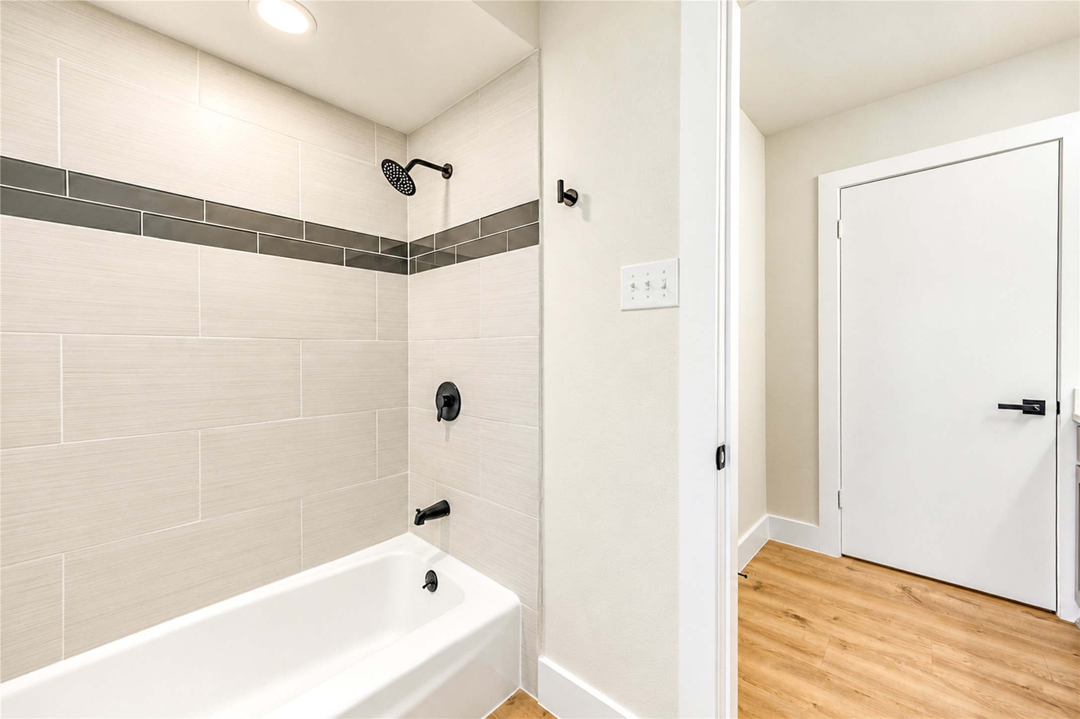 Beautifully remodeled tub and shower surround showcases elegant 12x24 porcelain tile with decorative glass mosaic inserts, complemented by all-new plumbing fixtures and contemporary finishes. Home features all-new PEX plumbing throughout!