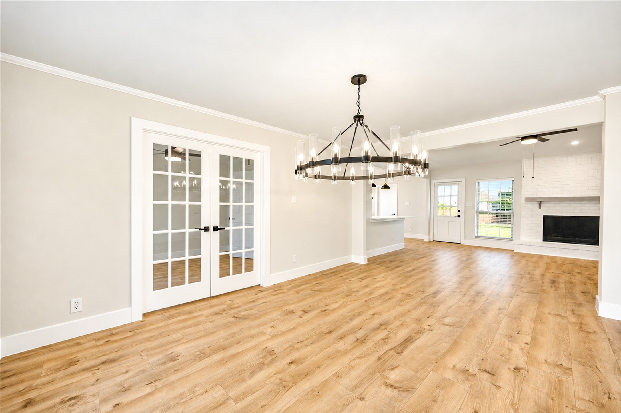 Another view of the formal dining room highlights the new designer chandelier, and seamless connection to the family room.  Beyond the new double French doors is a convenient home office/study.