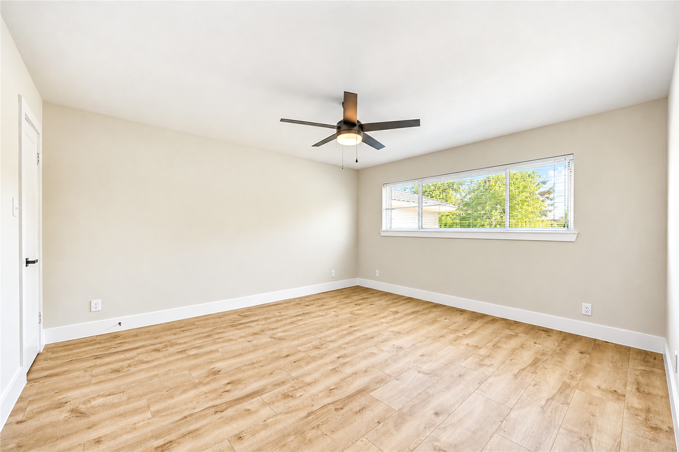 Spacious primary retreat features new wide-plank engineered wood flooring, a contemporary ceiling fan, abundant natural light, and TWO walk-in closets!