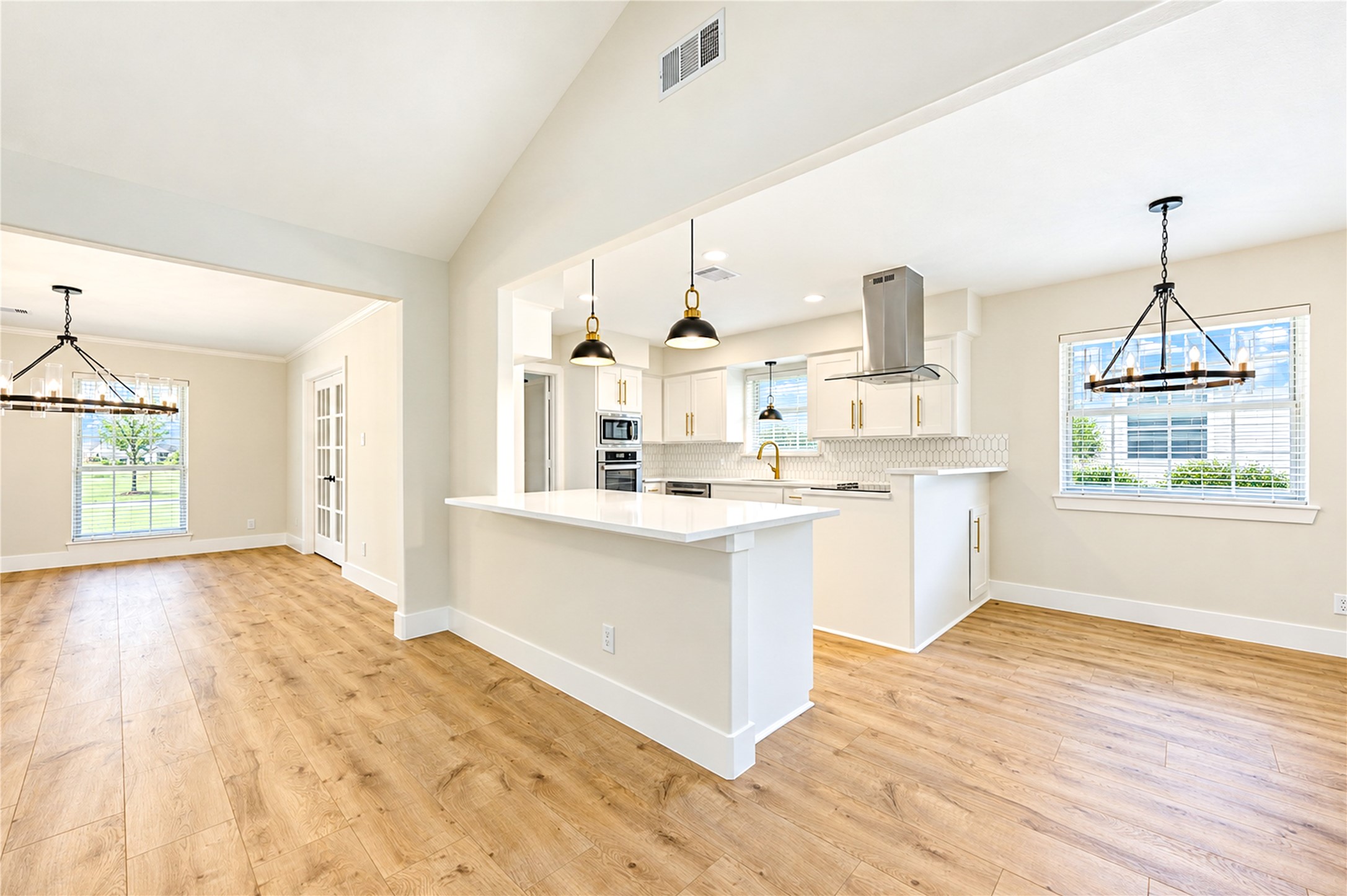 Beautifully designed open-concept layout connects the kitchen and family room, with generous breakfast bar seating and stylish designer pendant lighting.
 Copy