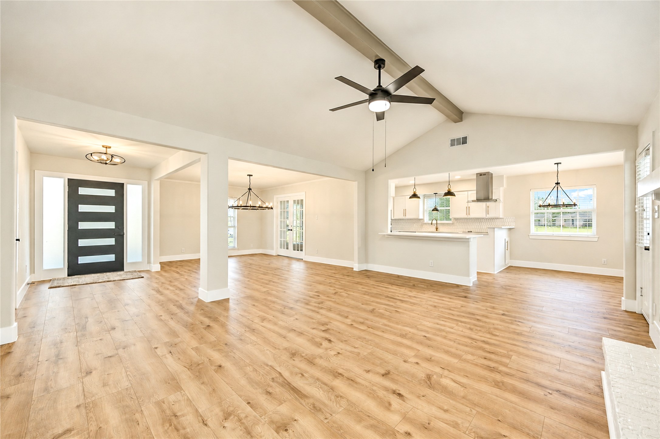 Beautifully redesigned open floor plan seamlessly connects the family room, kitchen, and dining areas, complemented by new wide-plank engineered wood flooring and updated designer lighting.