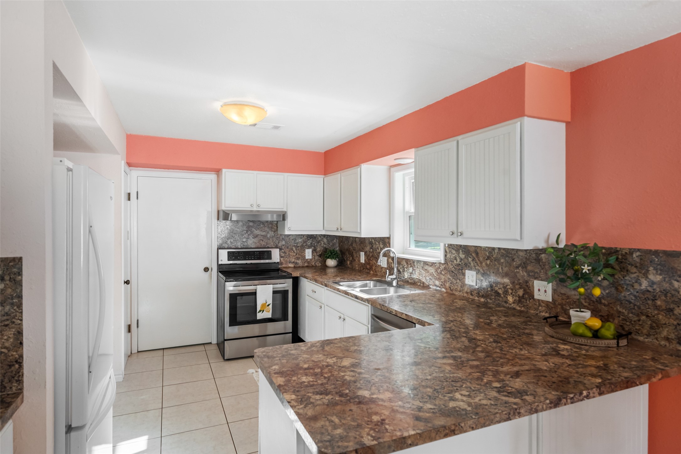 The door ahead is leads to a large laundry room, and the pantry closet and additional shelving are on the left side (next to the refrigerator).