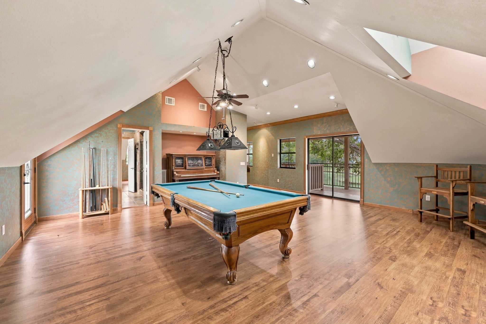 Take a look from the opposite side of the Game Room to appreciate the generous size of this versatile space, which offers convenient direct access to the full bath and two balconies overlooking the beautiful surroundings. The pool table will remain with the property; however, the piano is excluded from the sale.