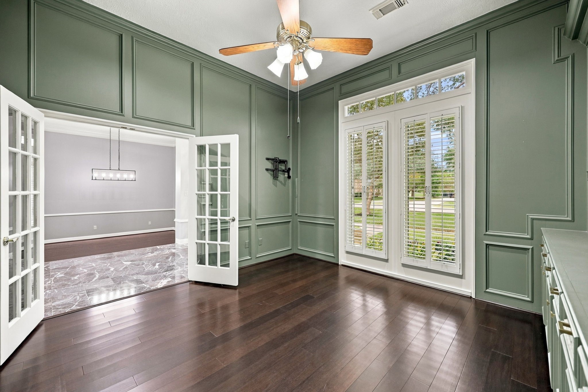 Located just off the main Foyer, the private Home Office is accessed through beautiful double glass-paneled doors, creating an elegant entrance while allowing natural light to flow into the space. The soothing mossy green paint color adds warmth and character, creating a calming yet sophisticated atmosphere.