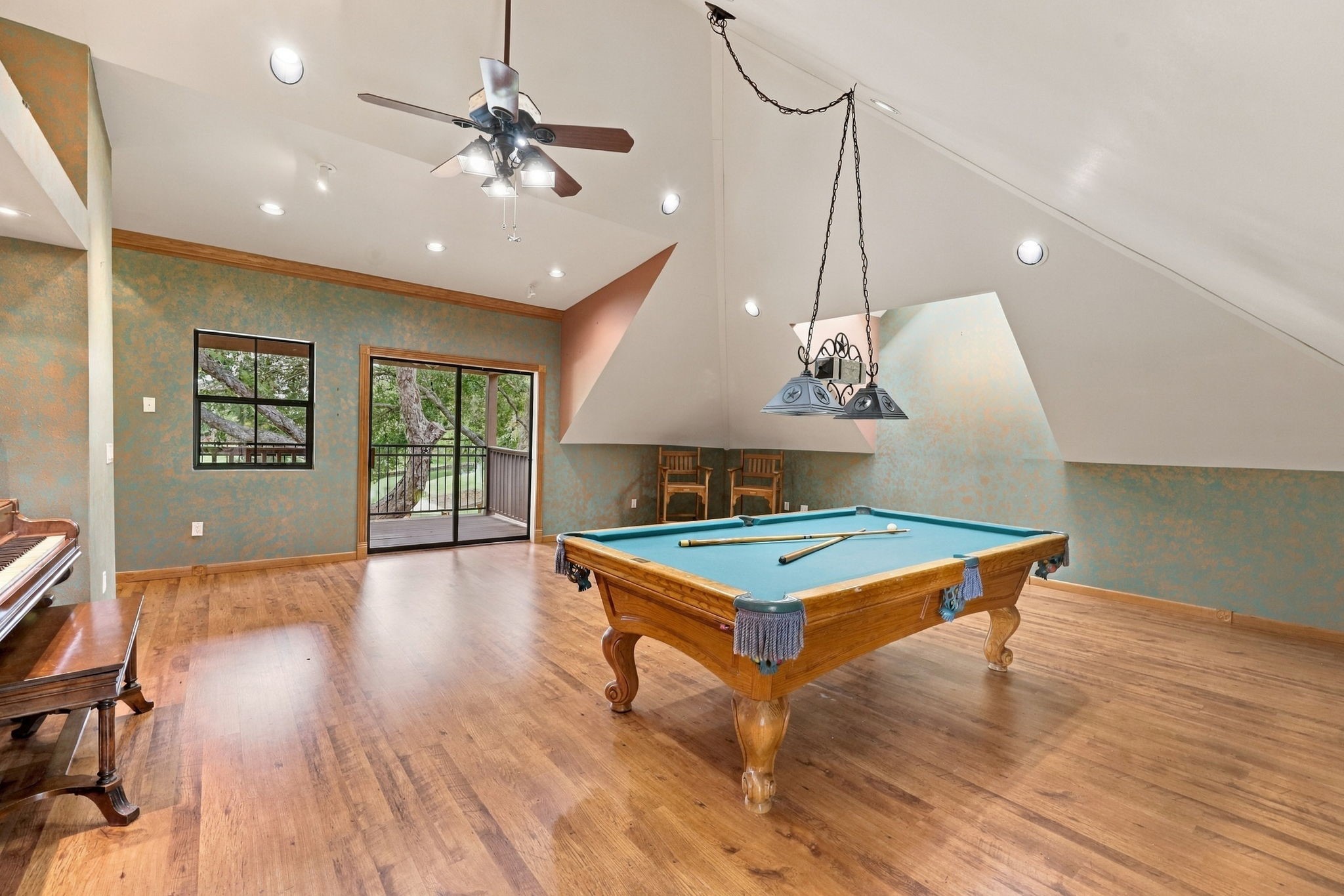 This versatile space can easily serve as an additional Bedroom, Game Room, or TV lounge, offering flexibility to suit your needs. Sliding glass doors open to the upstairs balcony, where you can enjoy beautiful waterfront views. The pool table will remain with the property, while the piano is excluded from the sale.