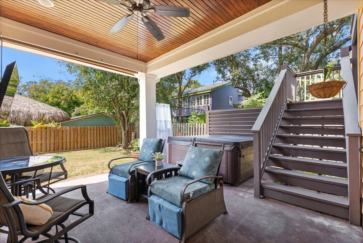 Unwind in the hot tub tucked beneath the covered patio, with a privacy curtain creating a secluded retreat.