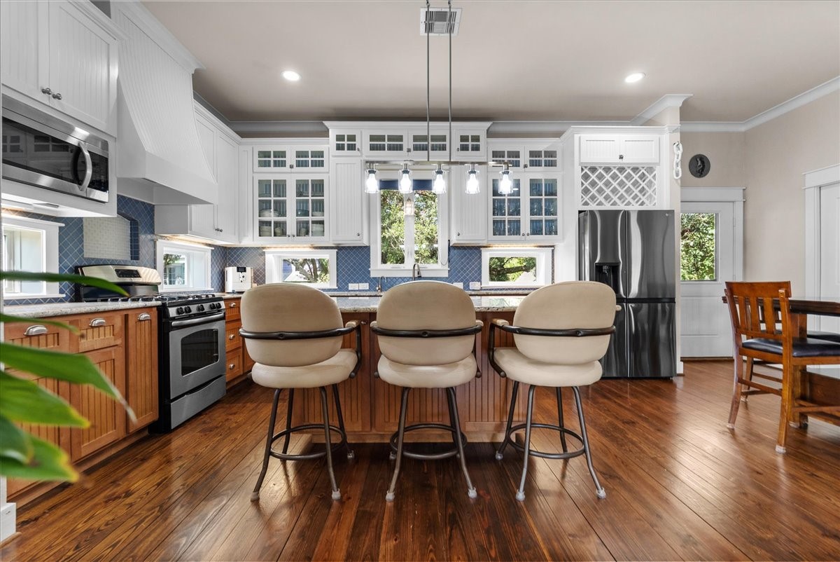 Bright, open kitchen featuring an oversized island and extensive custom cabinetry.