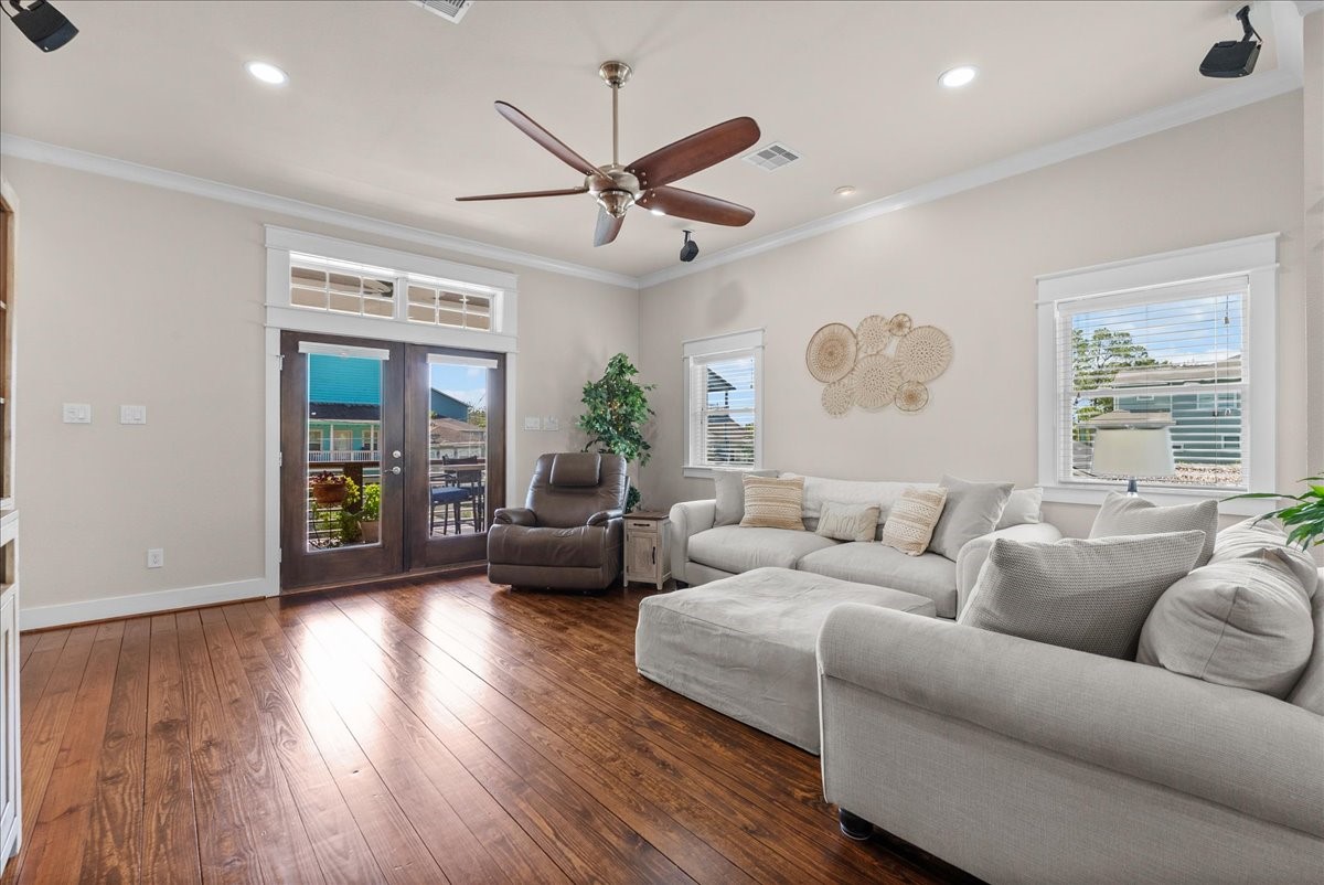Natural light fills the living room with double doors to the covered patio