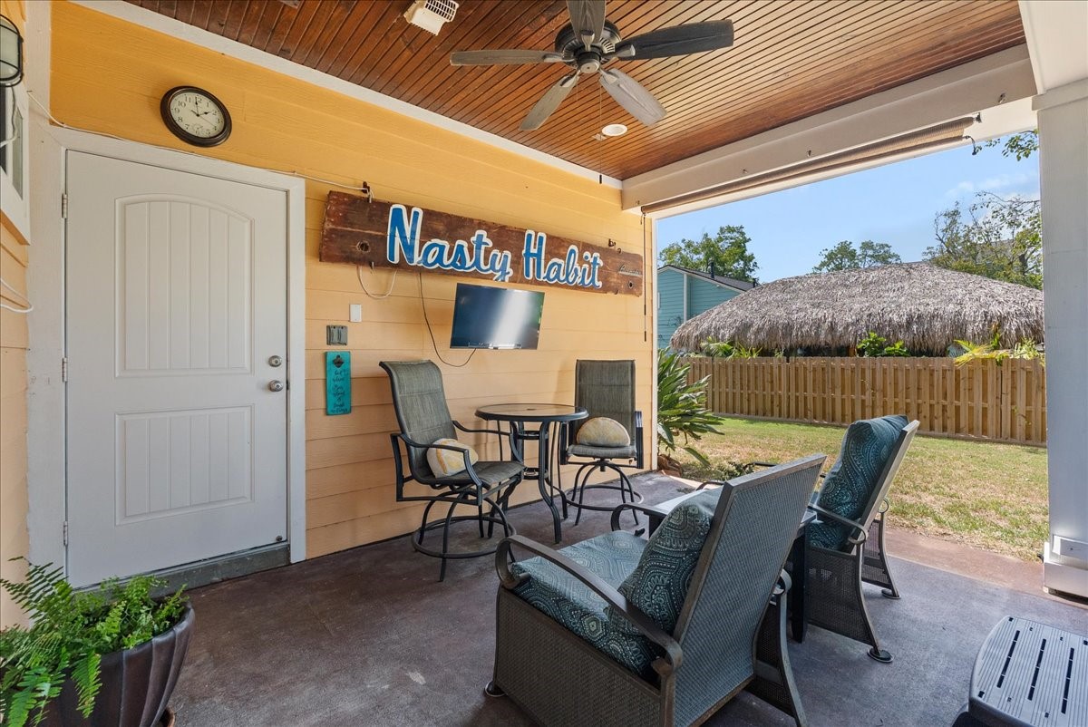 Inviting covered outdoor living areaperfect for relaxing or entertaining, with easy stair access to the kitchen.