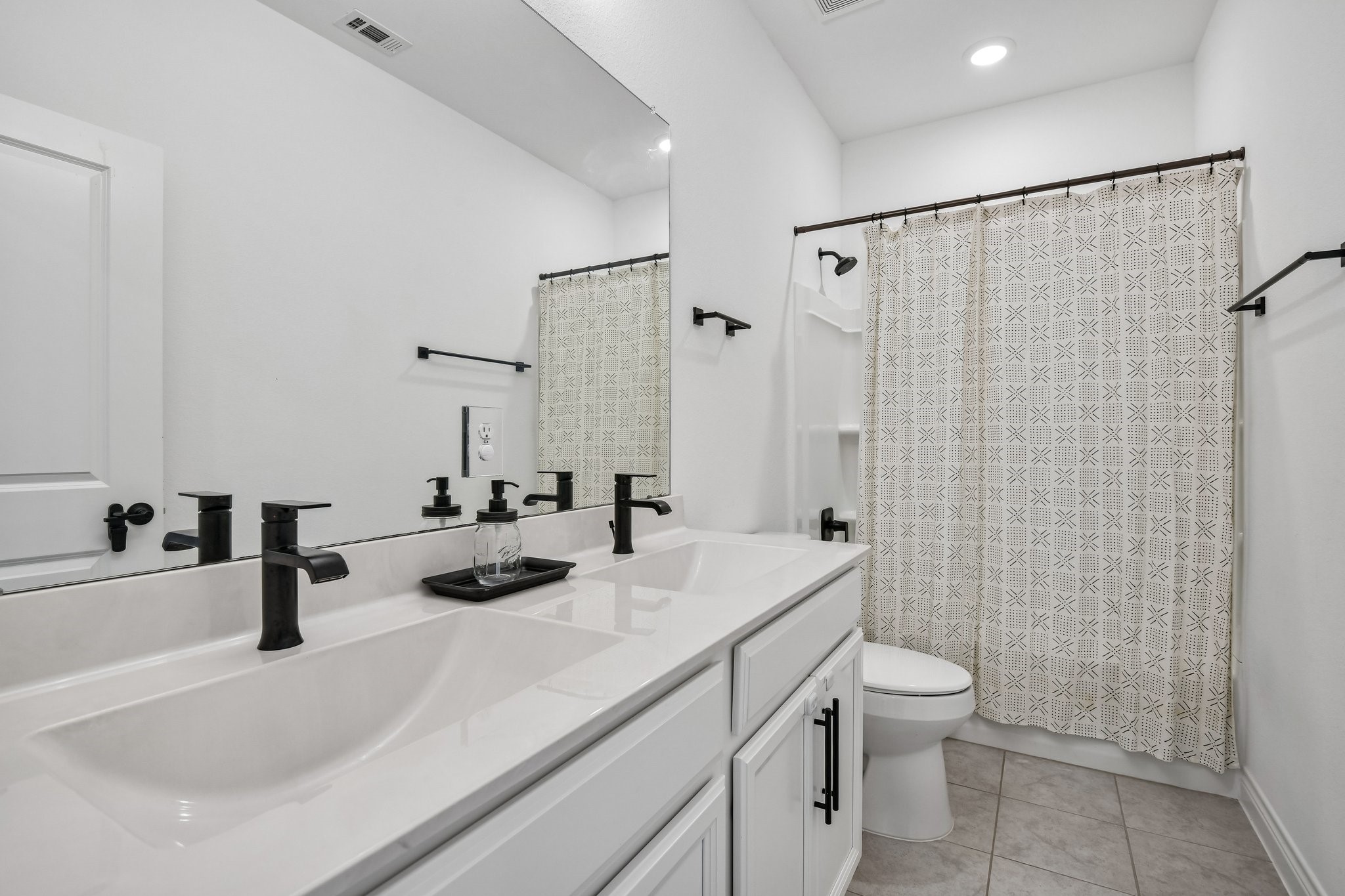 Secondary bath with dual sink vanity, ample counter space, and neutral finishes