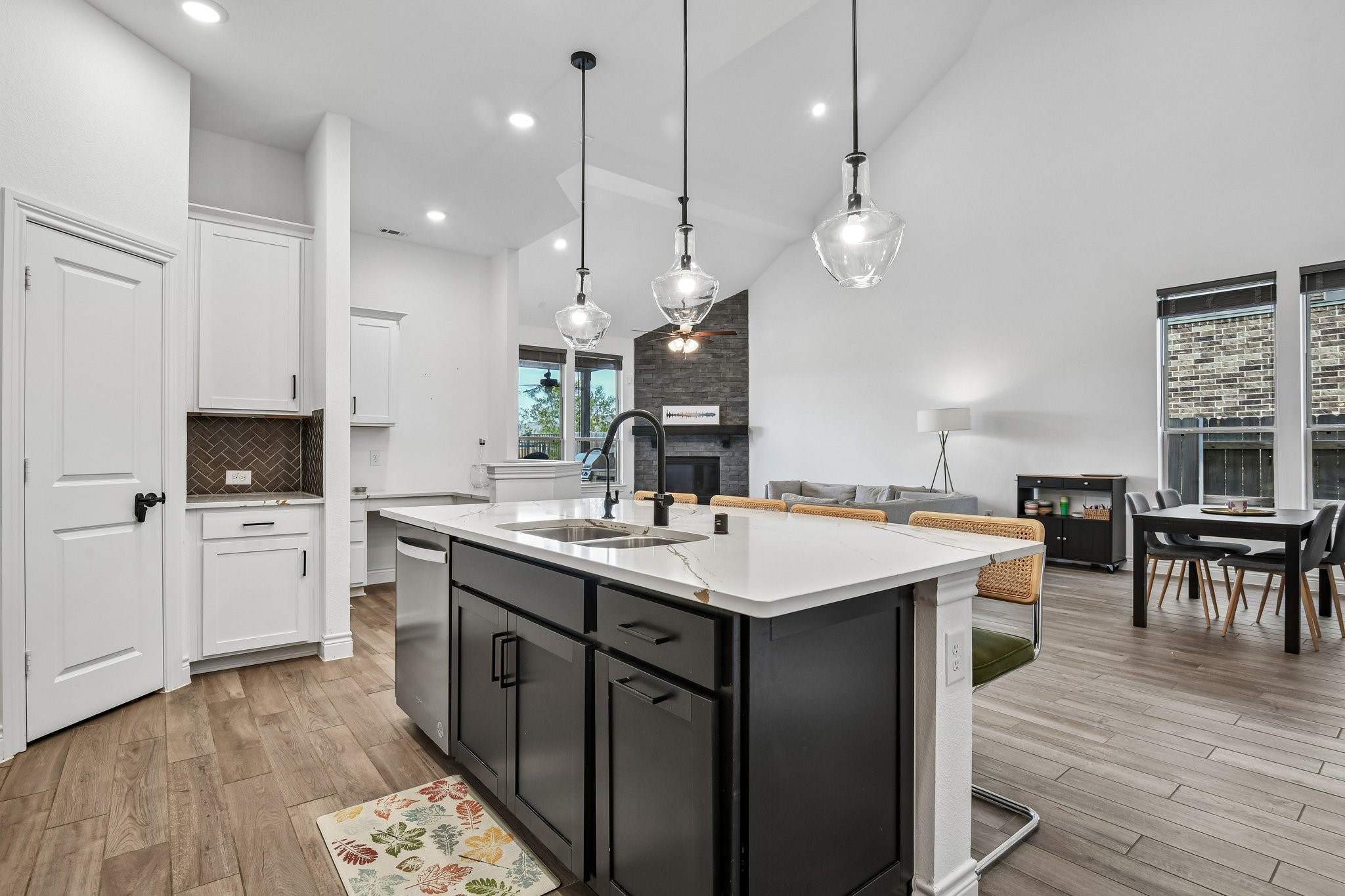 Large quartz island provides seating, storage, and a central gathering point for the home
