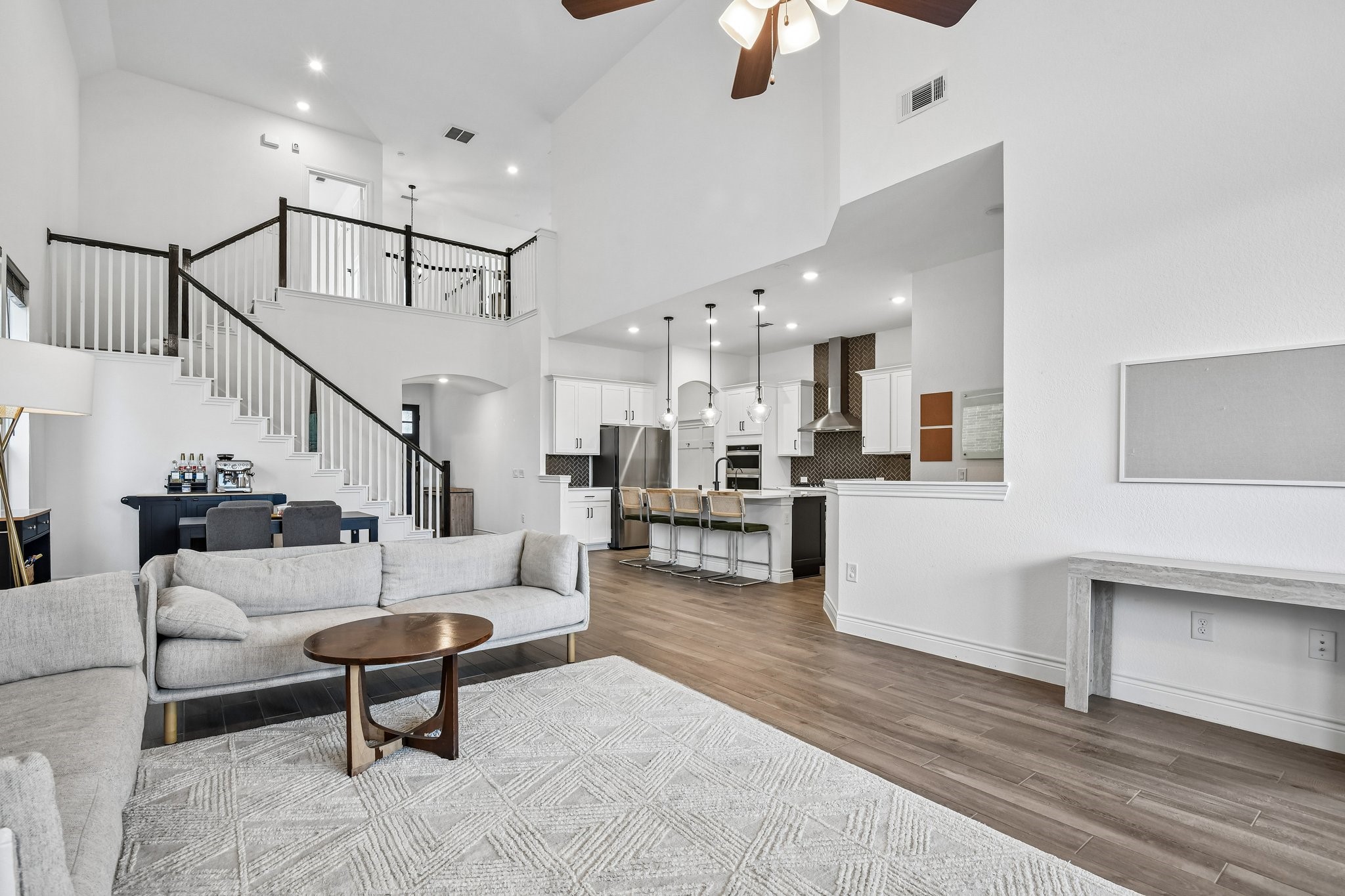 Two-story family room anchored by a floor-to-ceiling tile fireplace and dramatic wall of windows