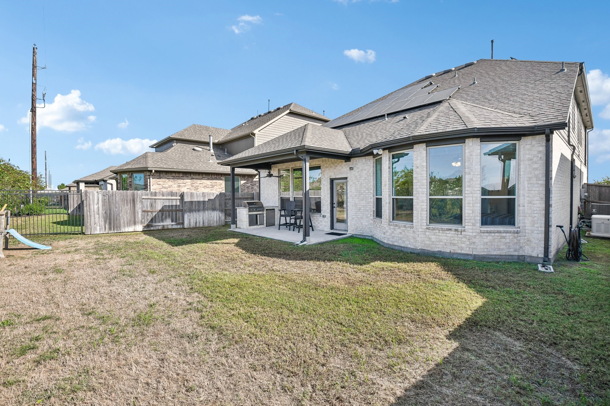 Rear elevation with covered patio, large windows, and direct access to the backyard