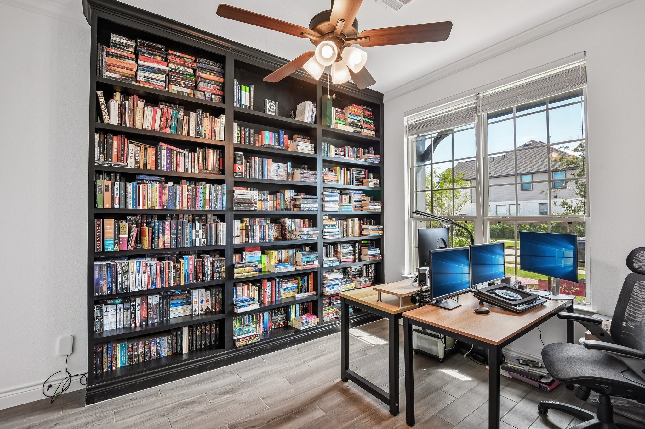 Private study off the entry with built-in shelving, natural light, and room for a full workspace