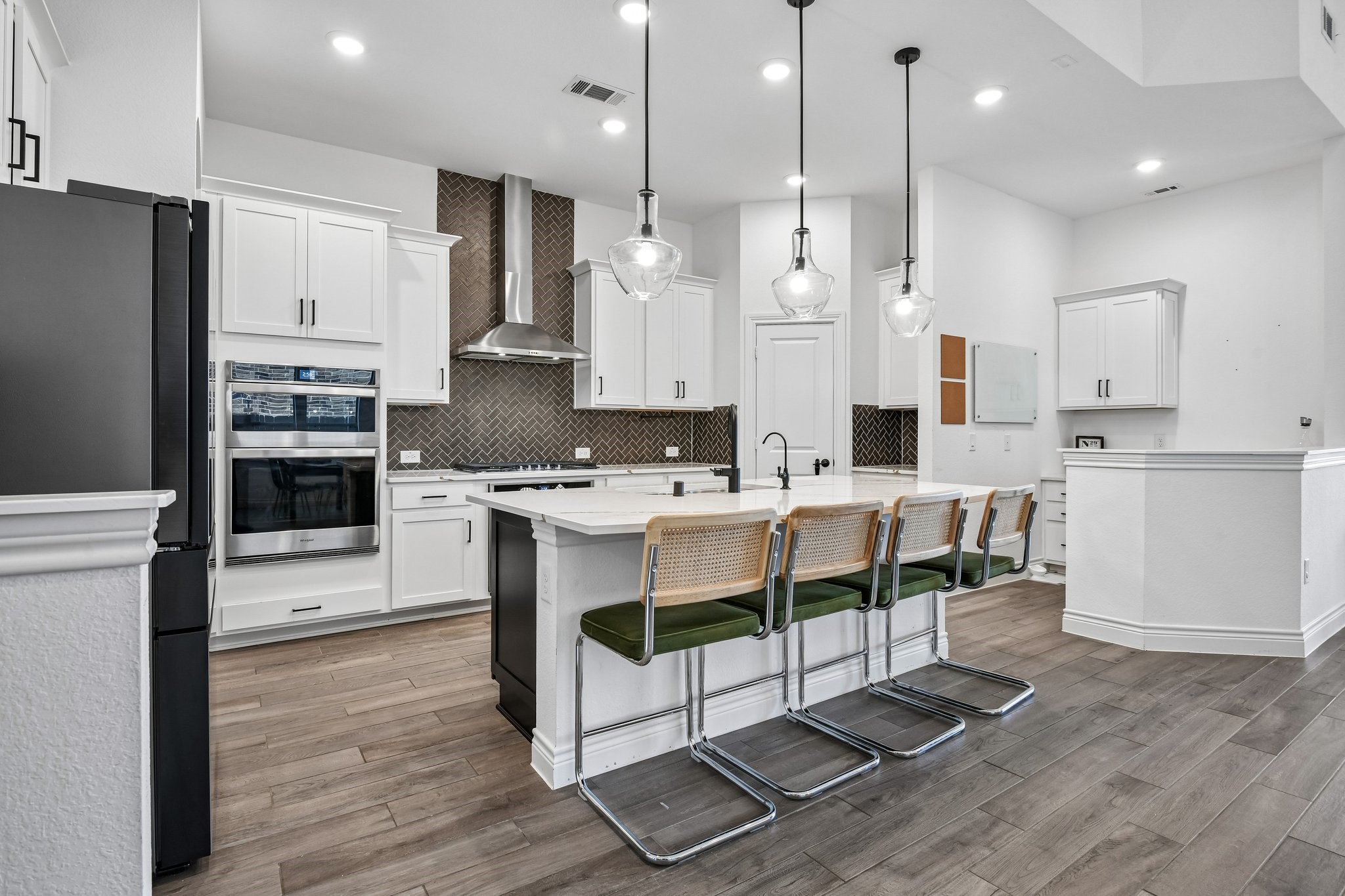 Kitchen view across the quartz island toward the family room and dining area