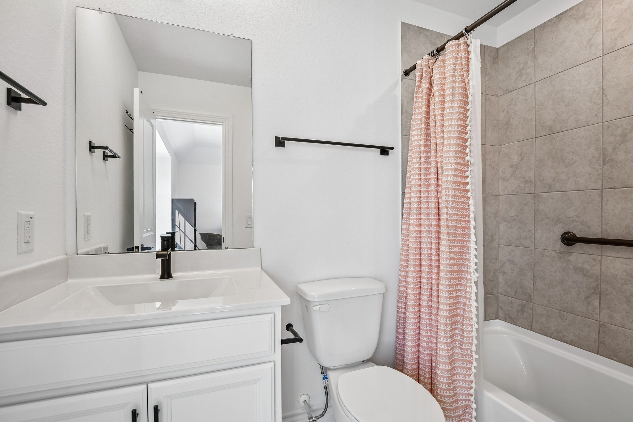 Full secondary bath with tub and shower combination and clean neutral finishes
